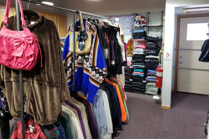 A store filled with clothes and a pink purse