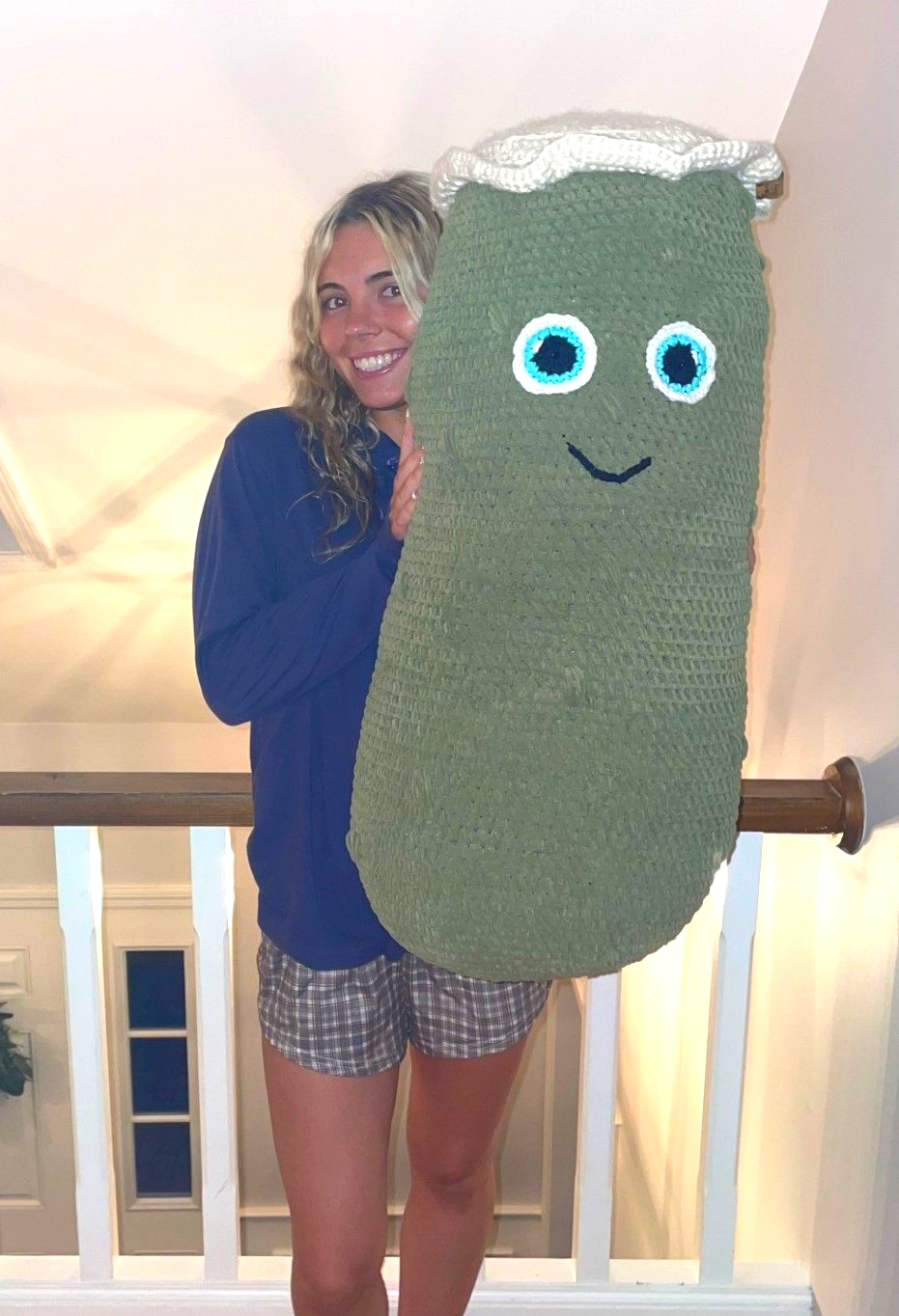 Crocheted white octopus with beige and pink tentacles, large googly eyes, sitting on a table.