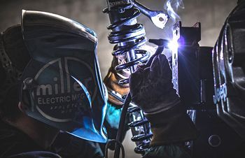 a man is welding a piece of metal in a factory .