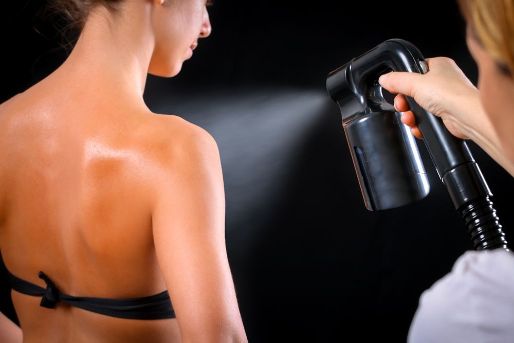 Woman Getting Spray Tan on Her Back — Pink Lily Beauty in Blacksmiths, NSW