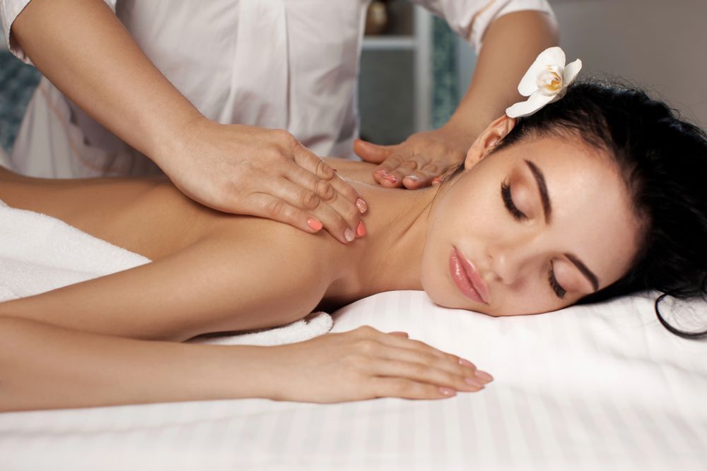 A Masseuse Is Pressing on Her Shoulders — Pink Lily Beauty in Blacksmiths, NSW