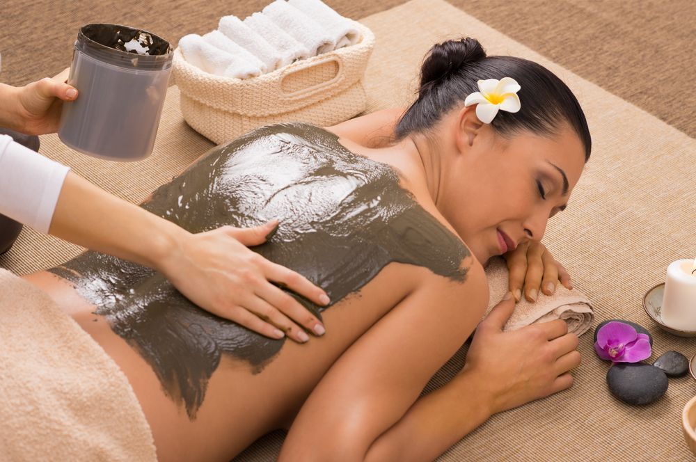 Woman Receiving Mud Treatment on Her Back at A Spa — Pink Lily Beauty in Blacksmiths, NSW