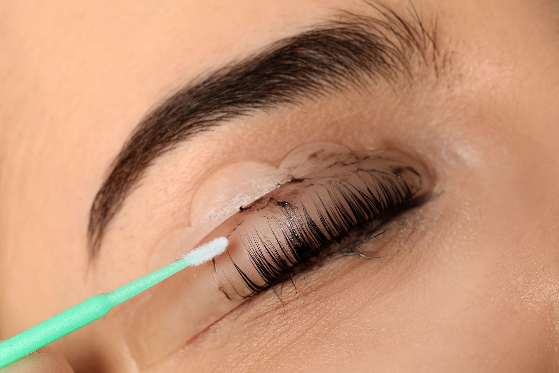 Dark Lashes Are Curled Around a Silicone Rod — Pink Lily Beauty in Blacksmiths, NSW
