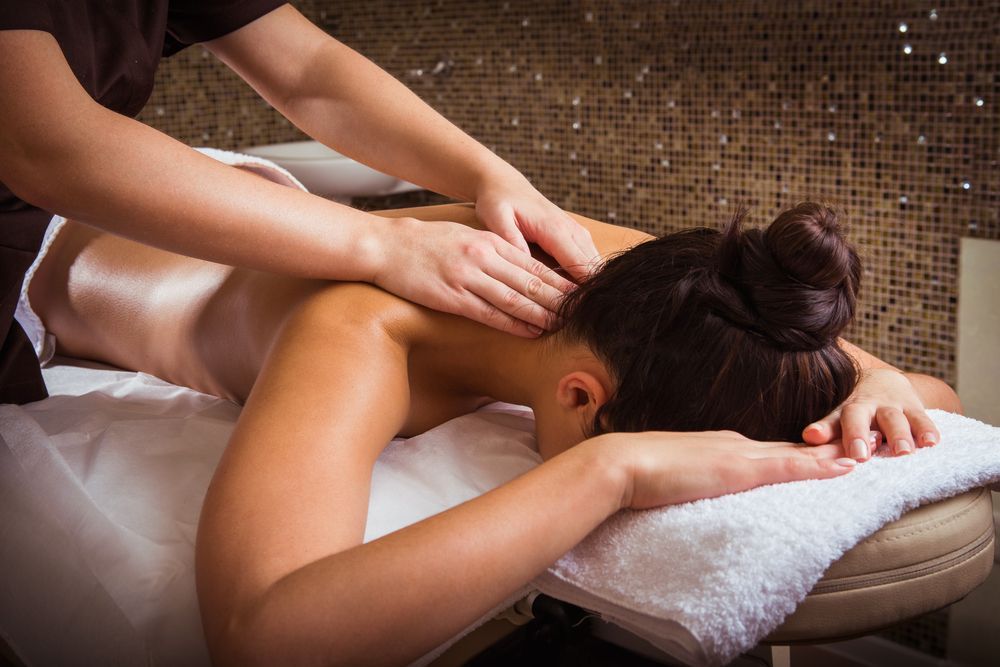Woman Receiving a Relaxing Back Massage at A Spa — Pink Lily Beauty in Blacksmiths, NSW