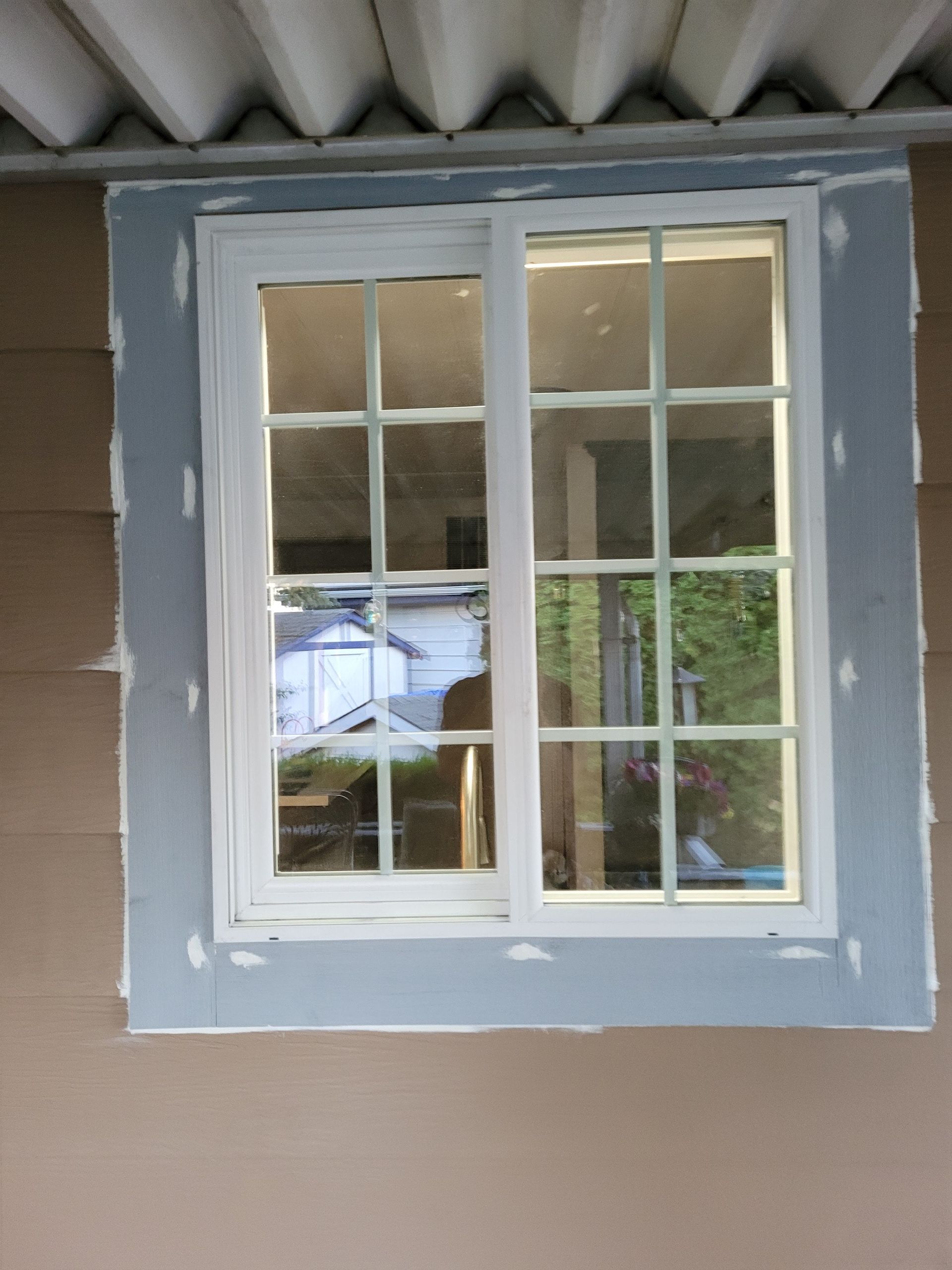 A window is being installed on the side of a house