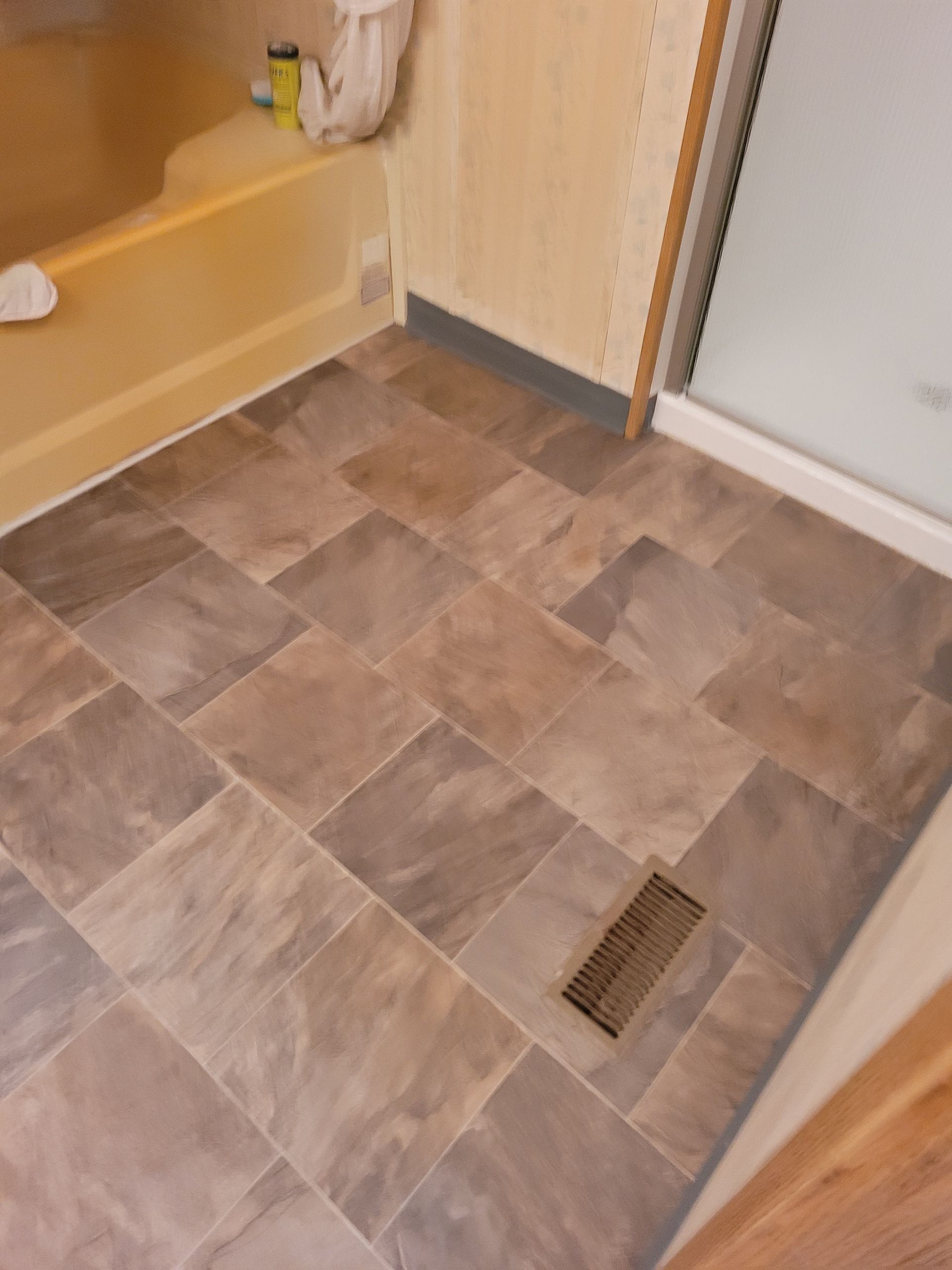 A bathroom with a tiled floor and a bathtub