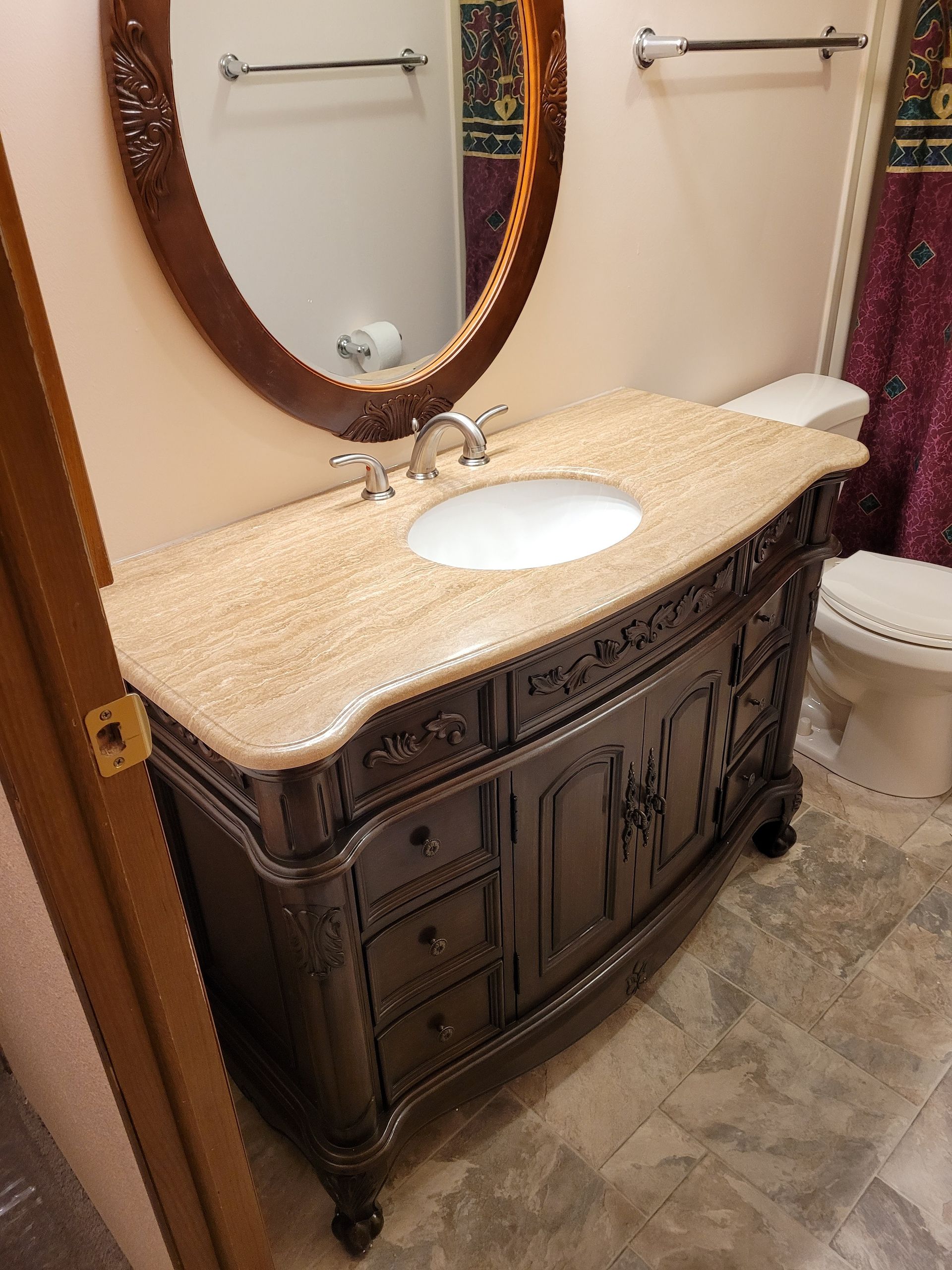 A bathroom with a sink , toilet and mirror.