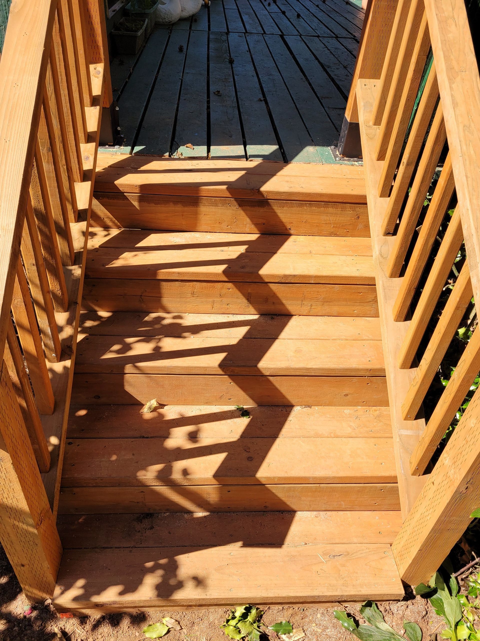 A set of wooden stairs leading up to a wooden deck