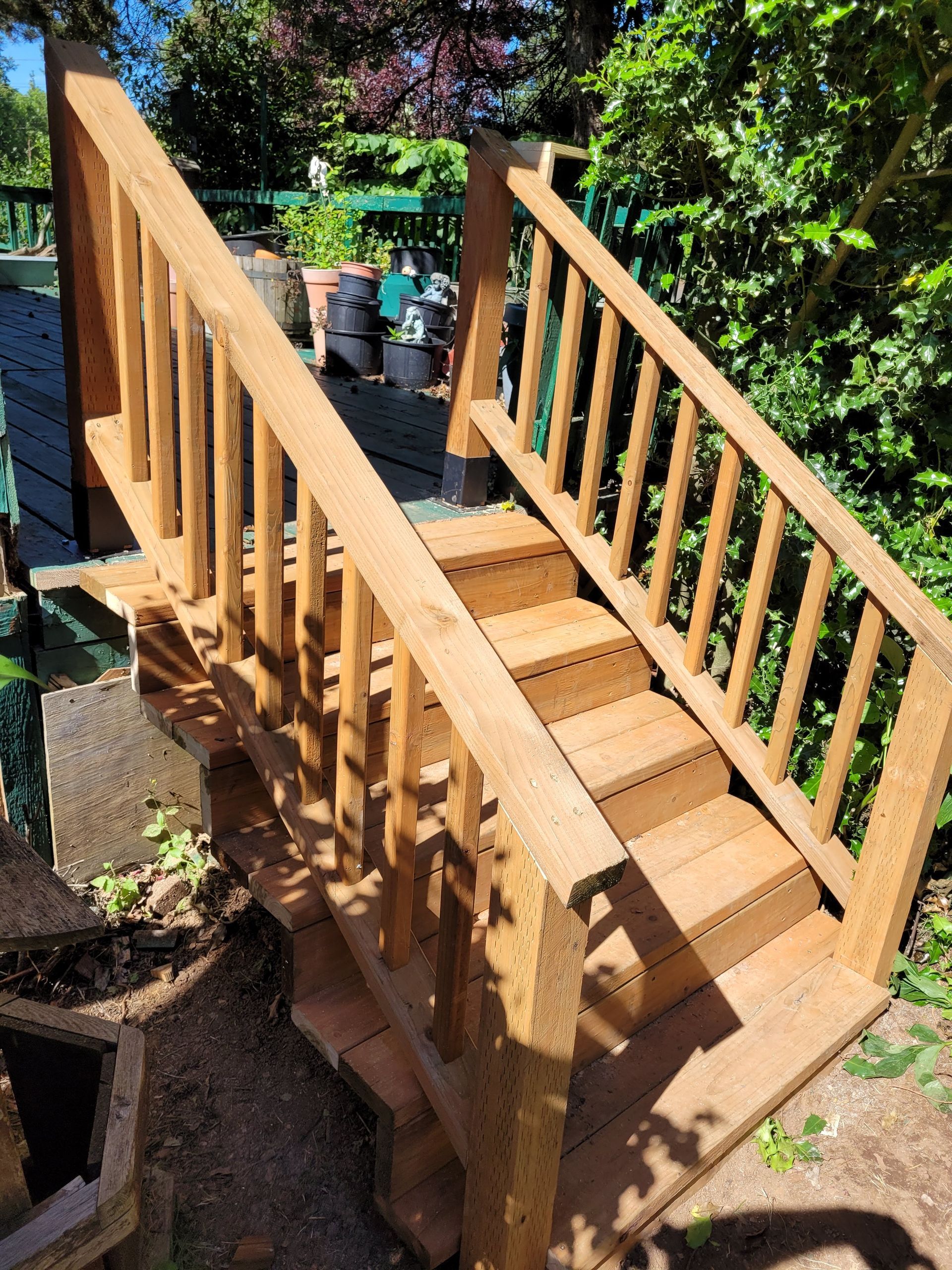 A wooden staircase with a railing in a garden