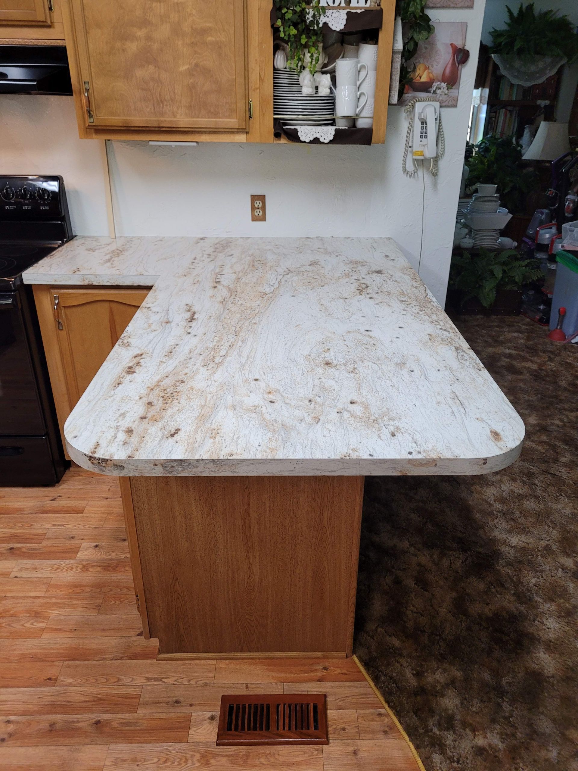 A kitchen with a granite counter top and wooden cabinets