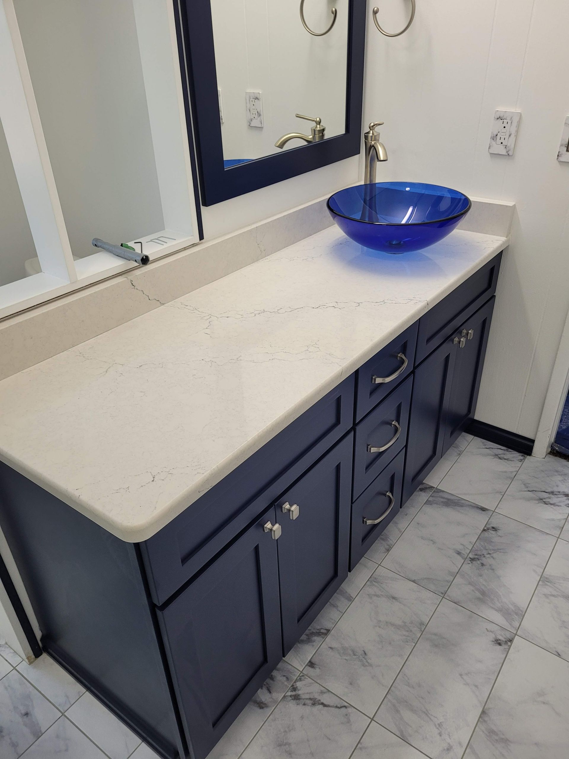 A bathroom with blue cabinets and a blue sink