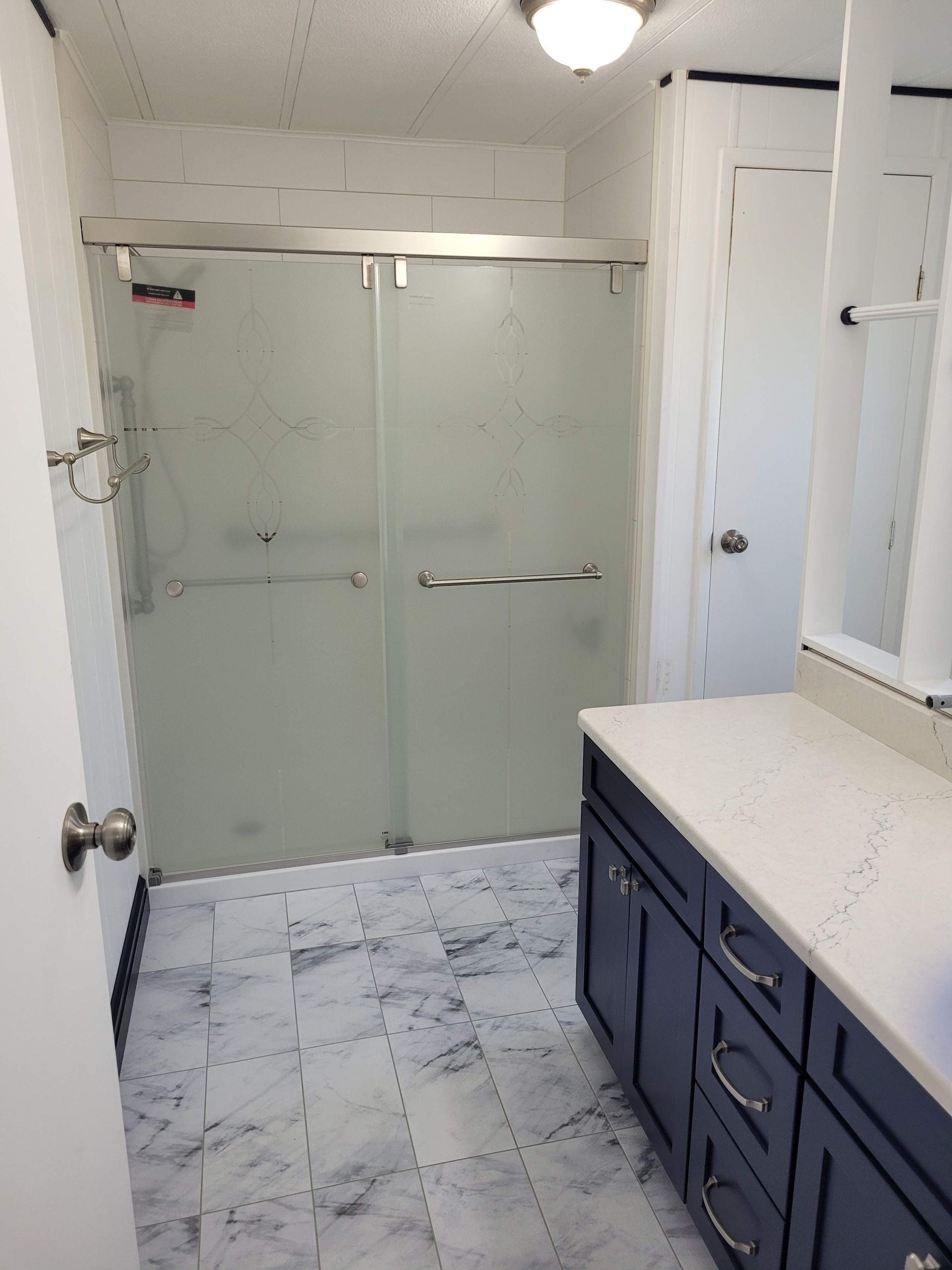 A bathroom with a sliding glass shower door and a sink.