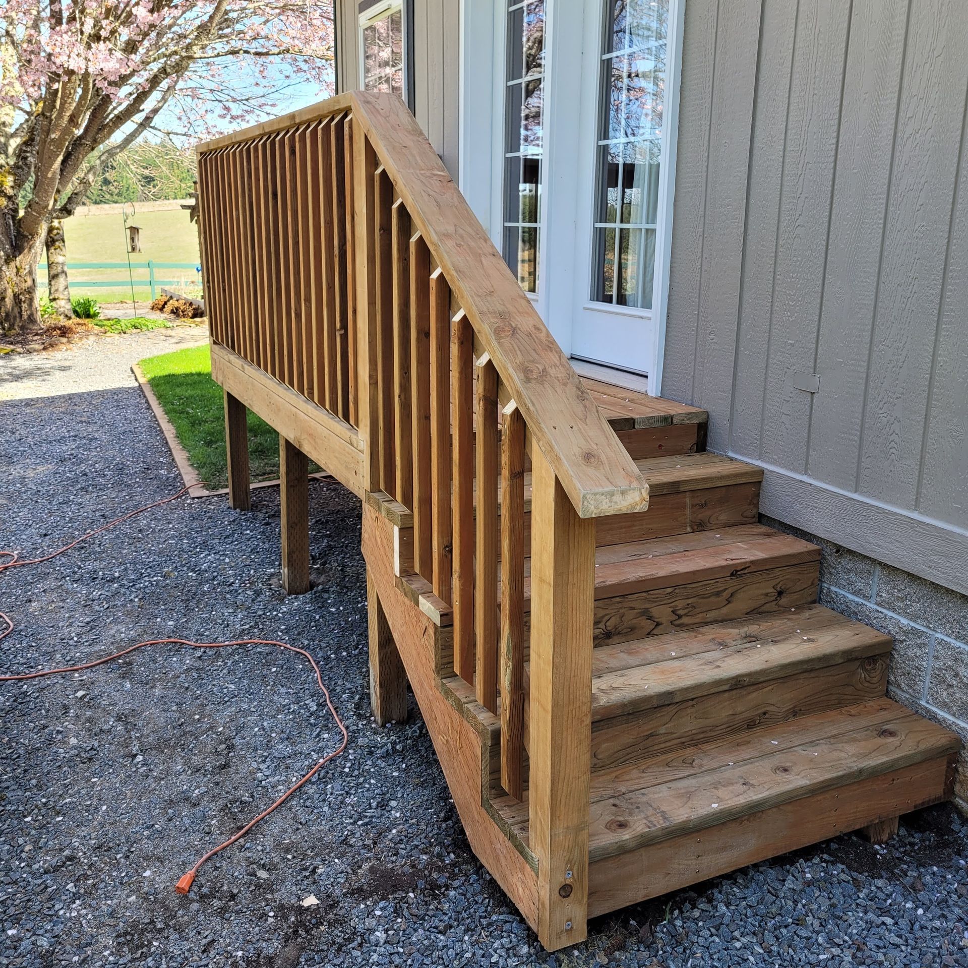 A wooden deck with stairs leading up to a house