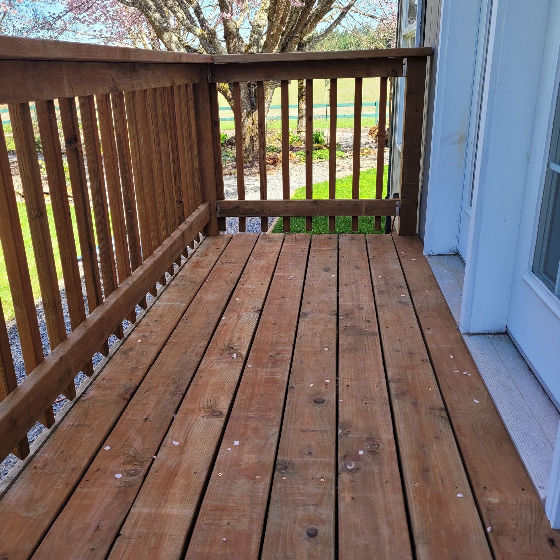A wooden deck with a railing and a window.