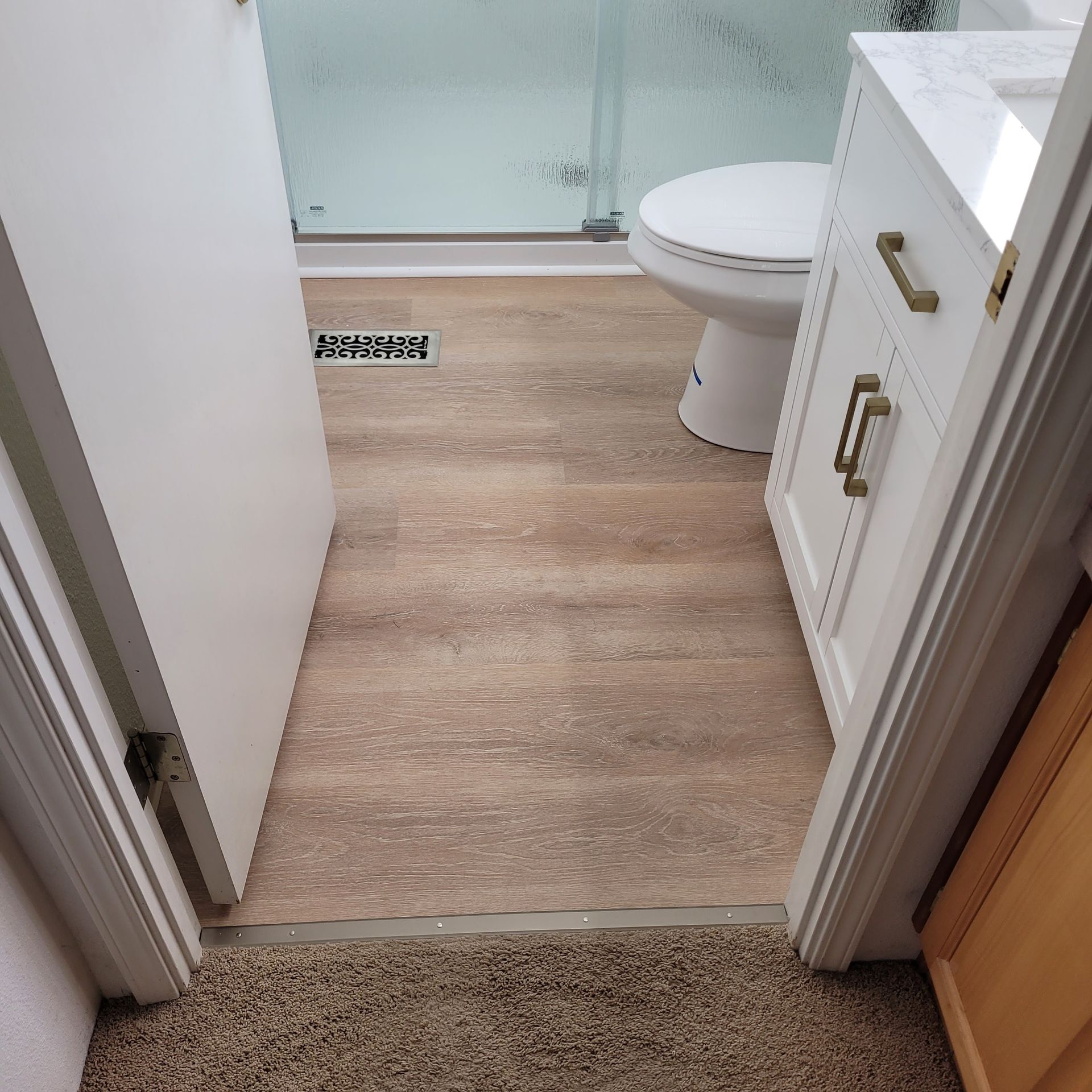 A bathroom with a toilet , sink and shower.