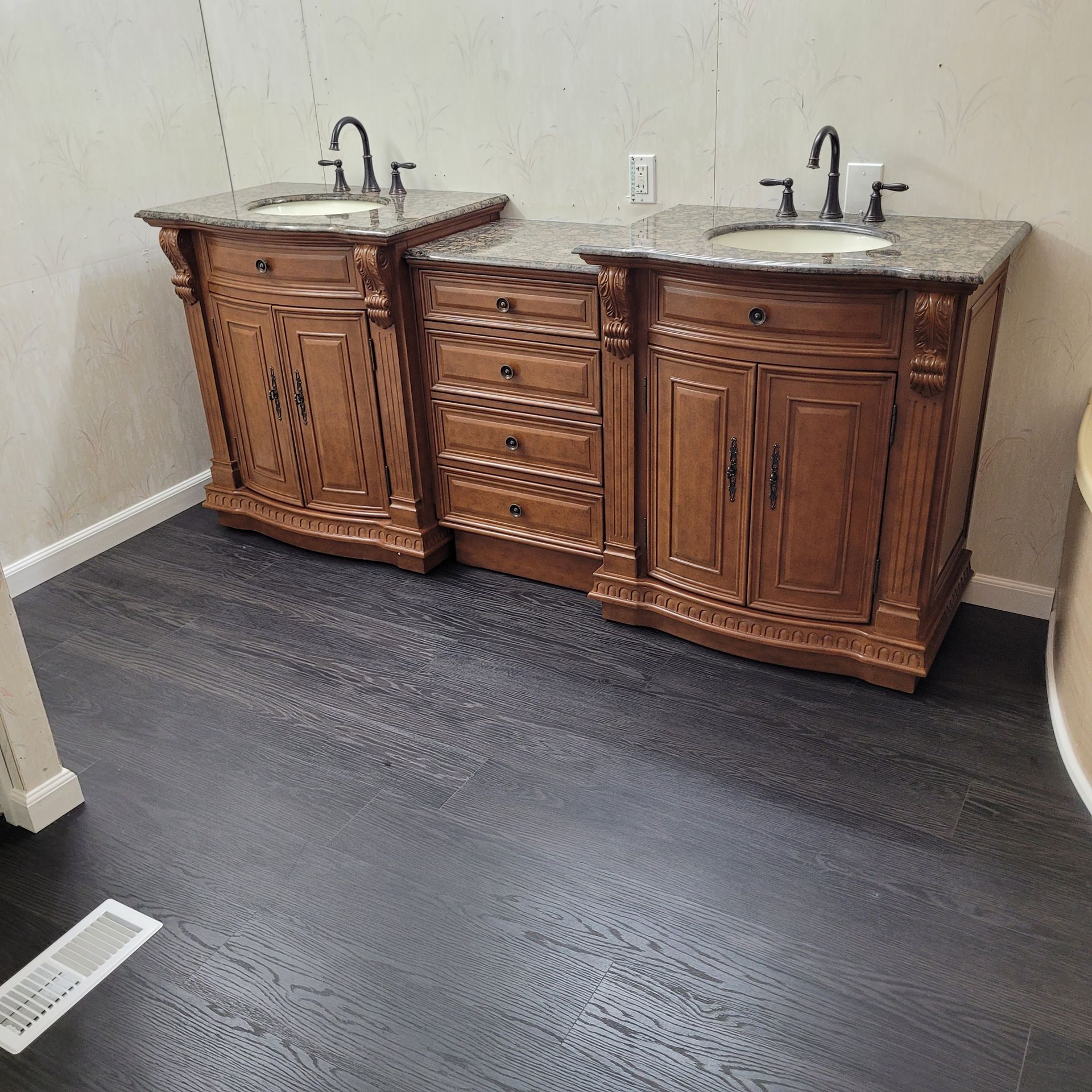 A bathroom with two sinks and wooden cabinets.