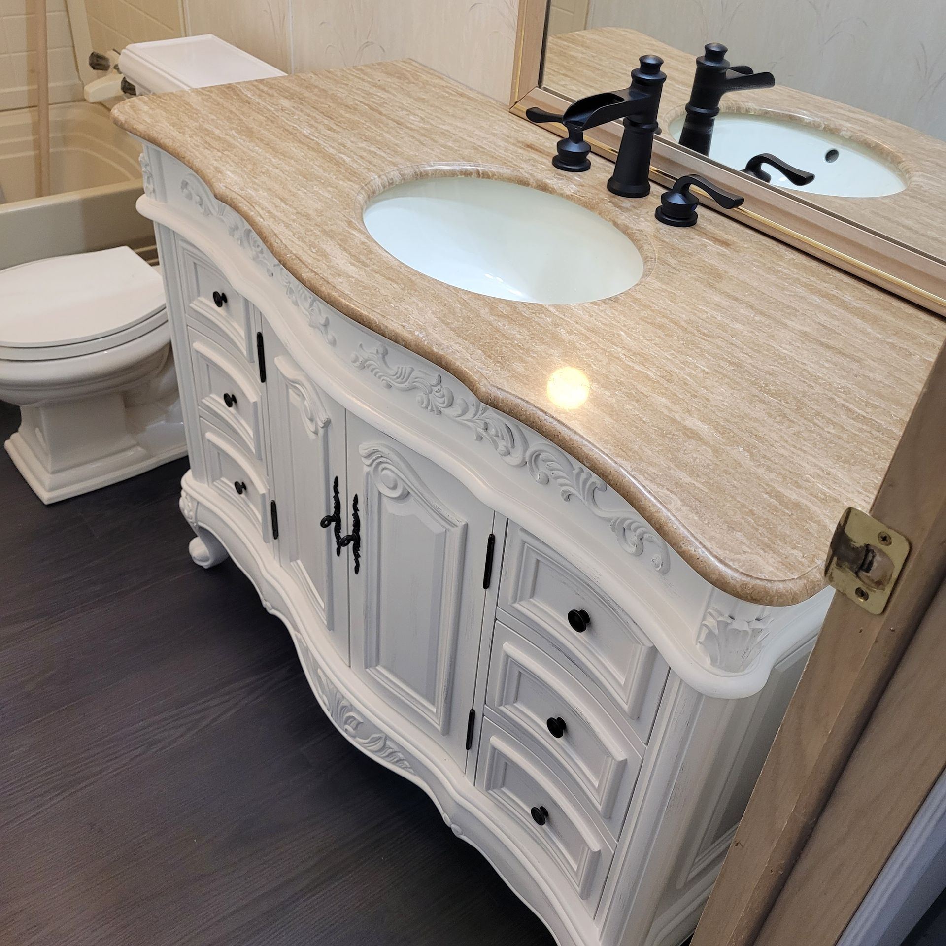 A bathroom vanity with a sink and a toilet
