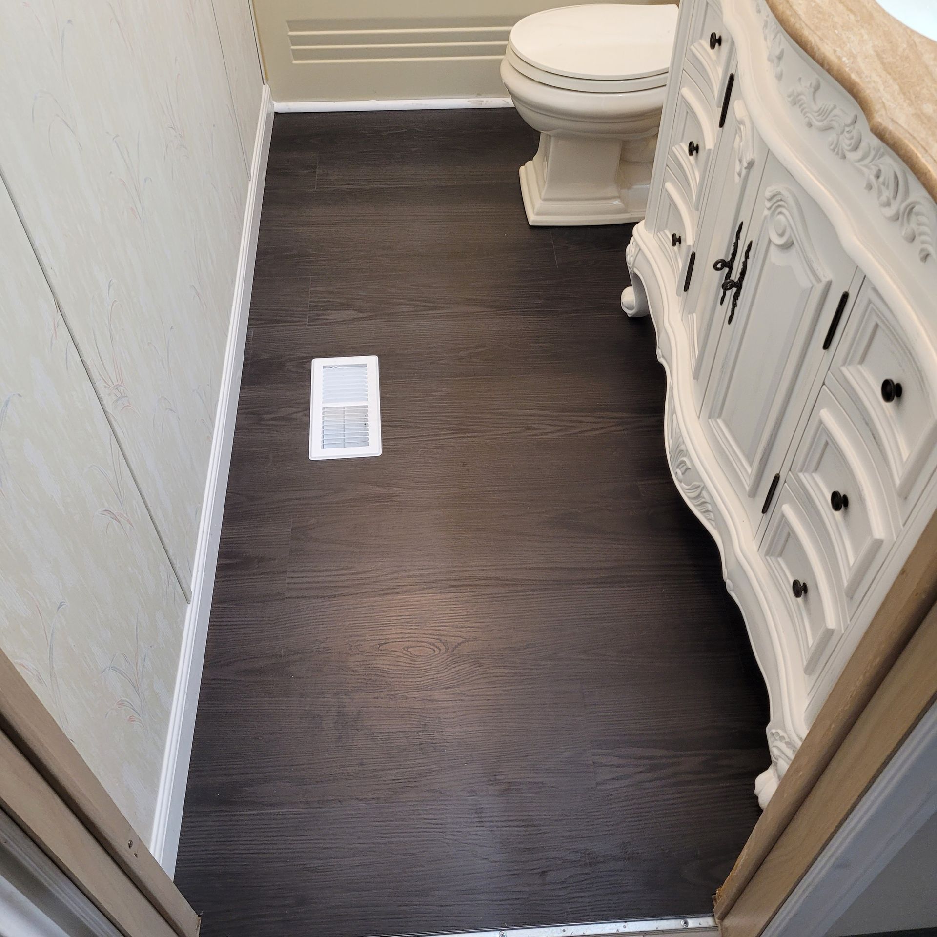 A bathroom with a white vanity and a toilet