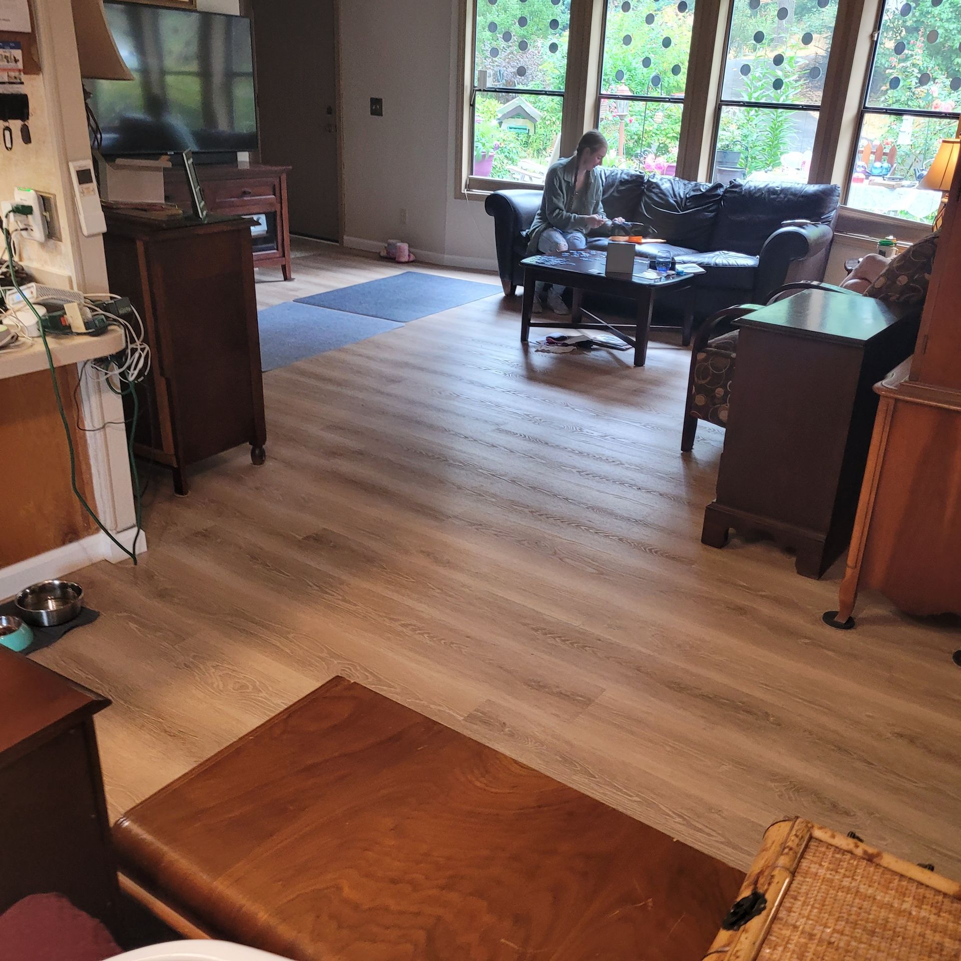 A living room with hardwood floors and a couch and chairs