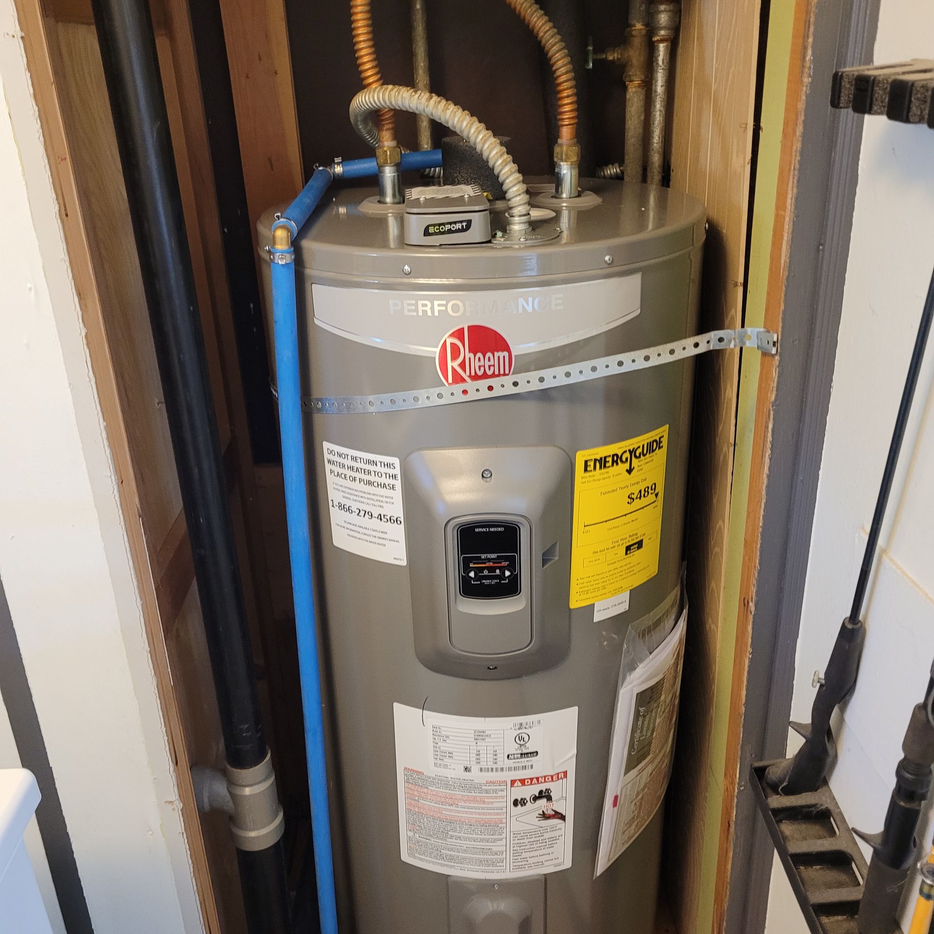 A rheem water heater is sitting in a cabinet