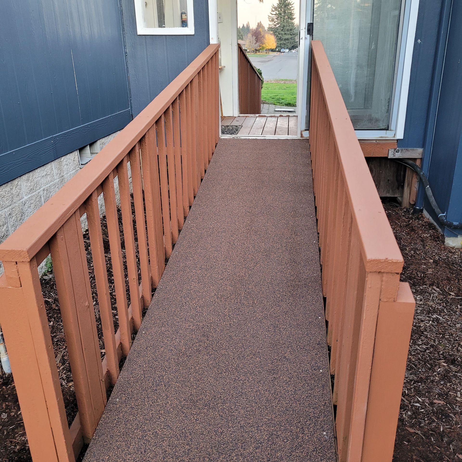 A ramp leading to a house with a wooden railing