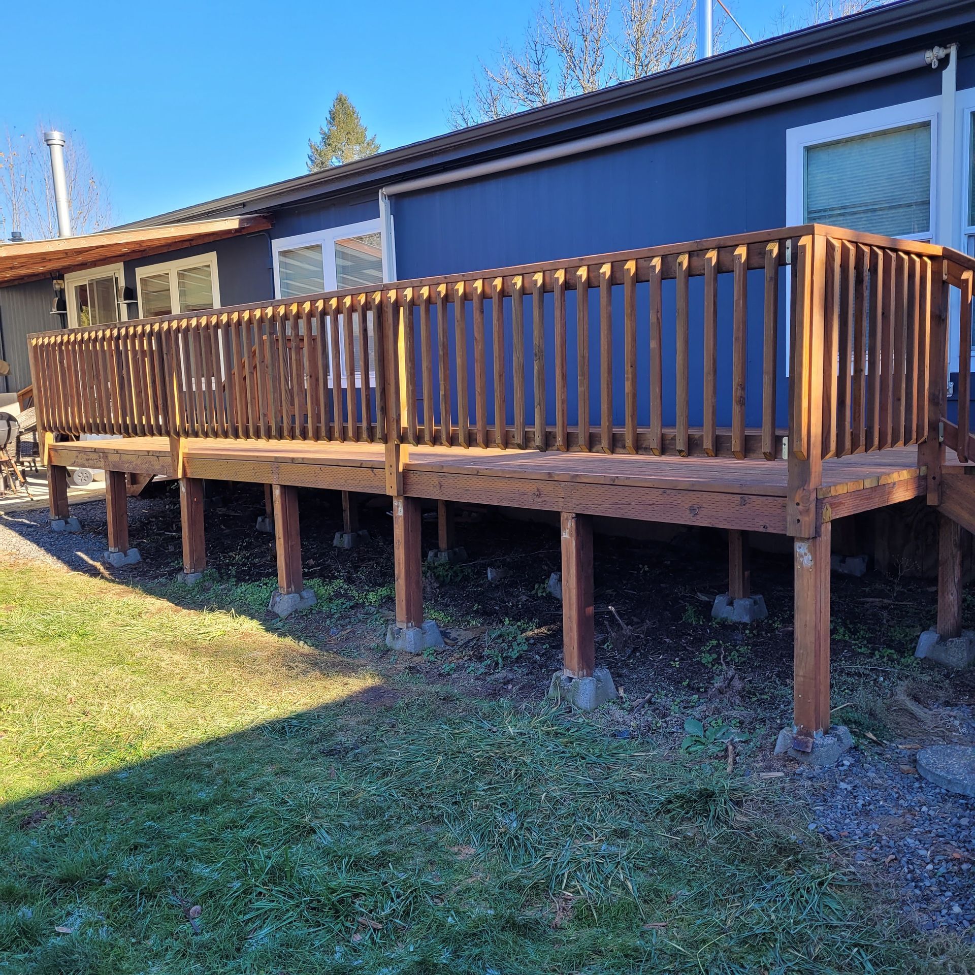 A blue house with a wooden deck in front of it