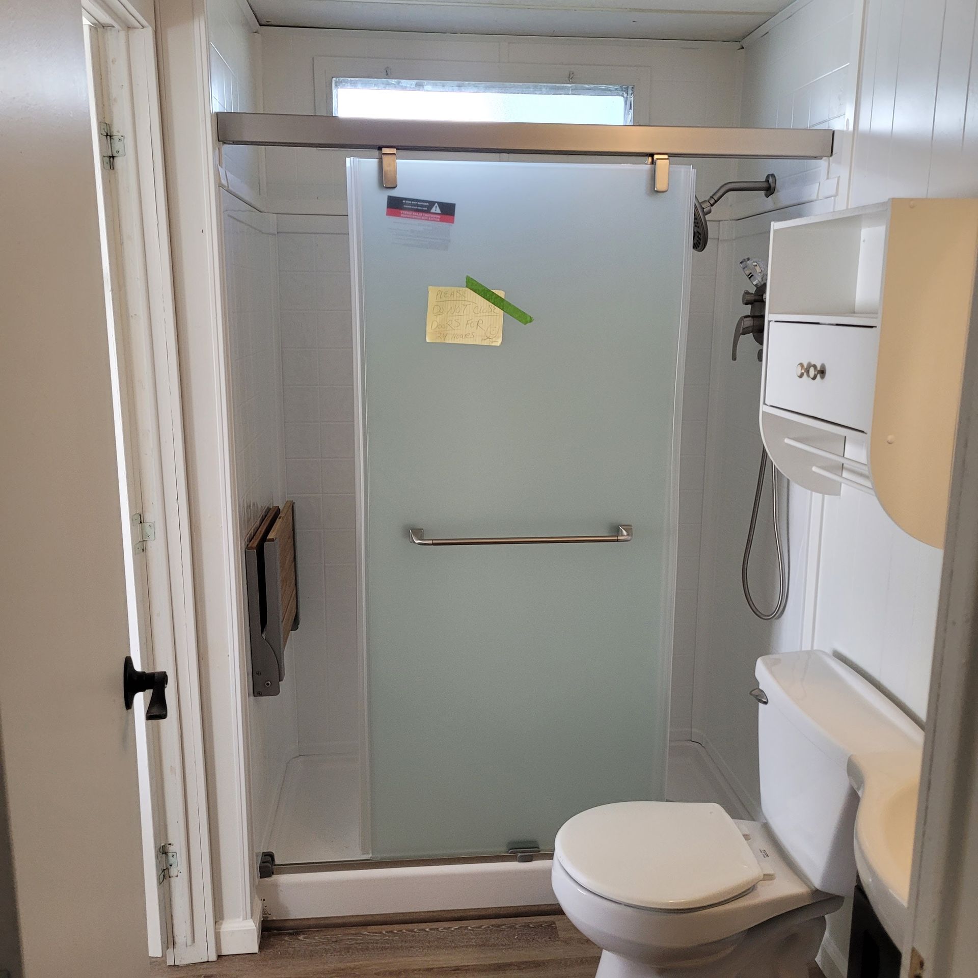 A bathroom with a toilet and a glass shower door