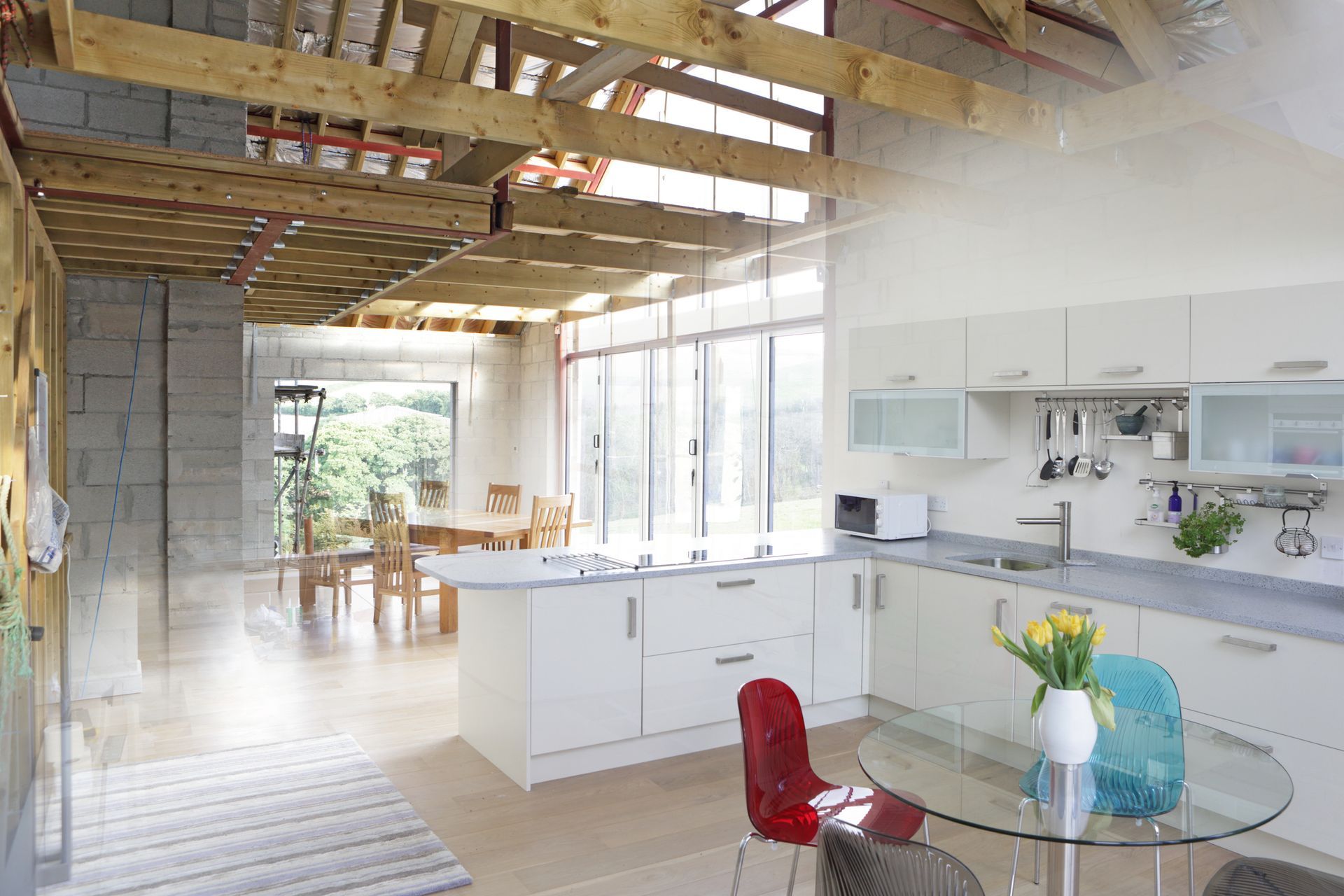 A kitchen with white cabinets and a glass table