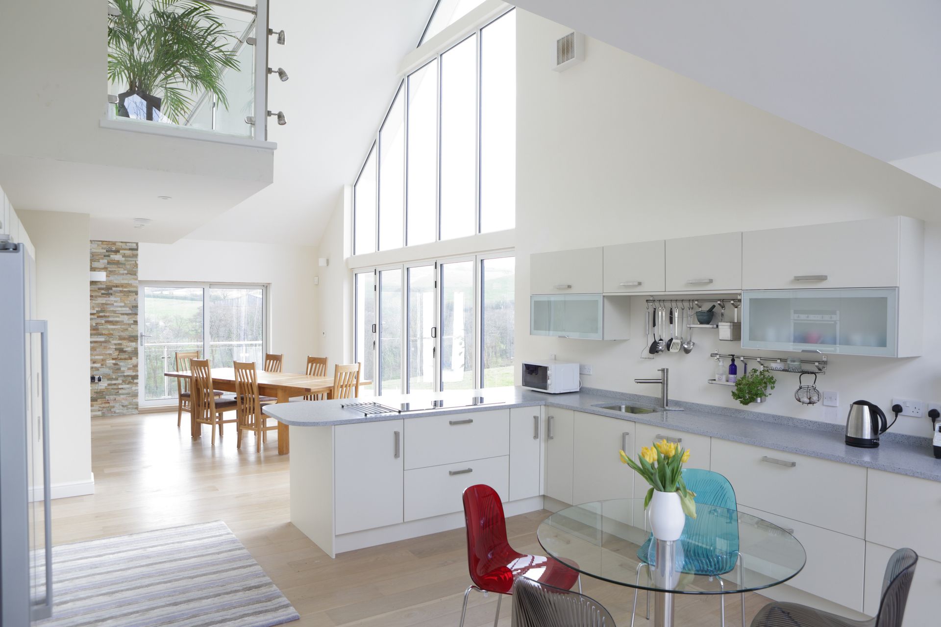 A kitchen with white cabinets and a glass table