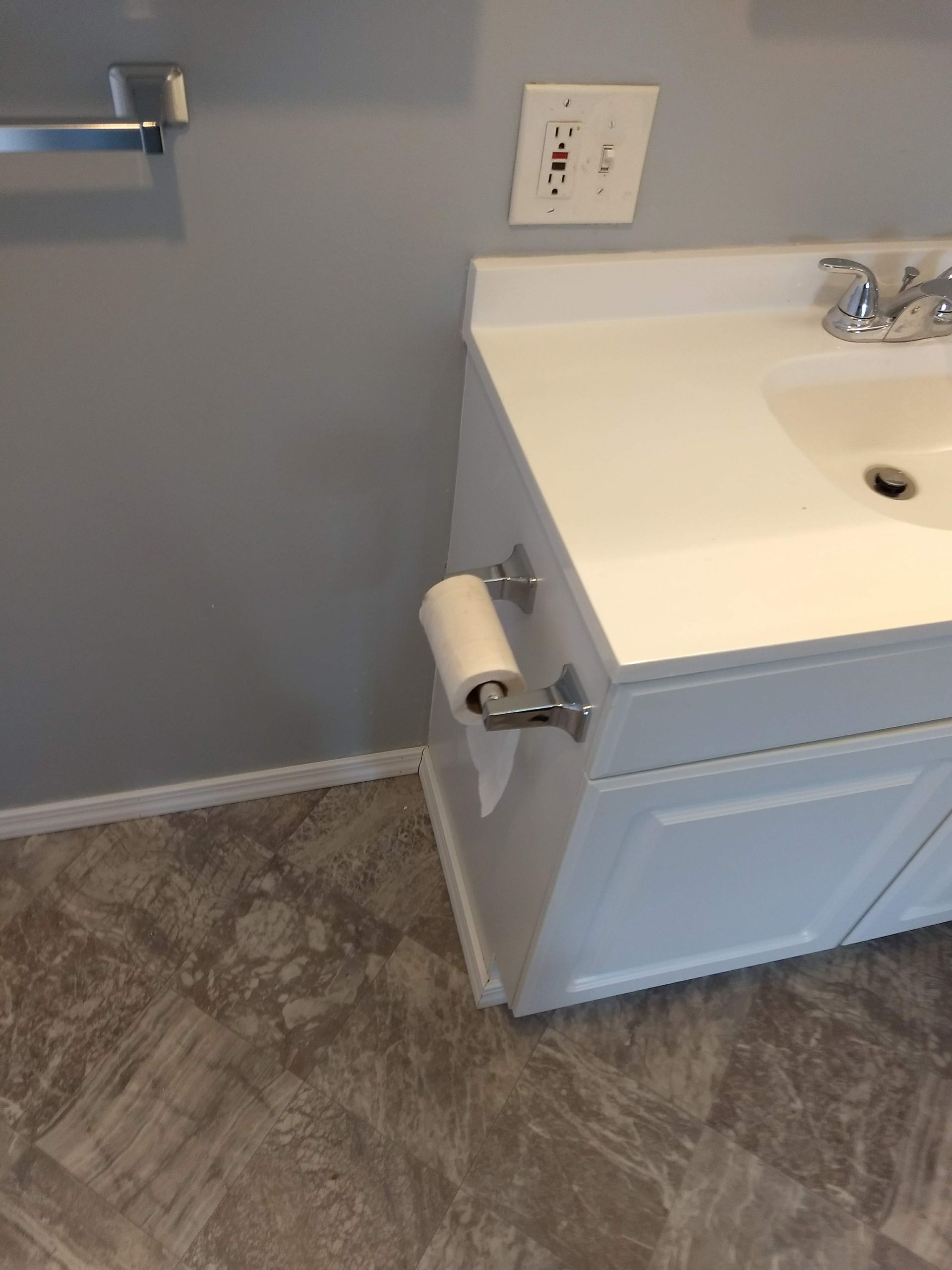 A bathroom sink with a paper towel holder next to it.