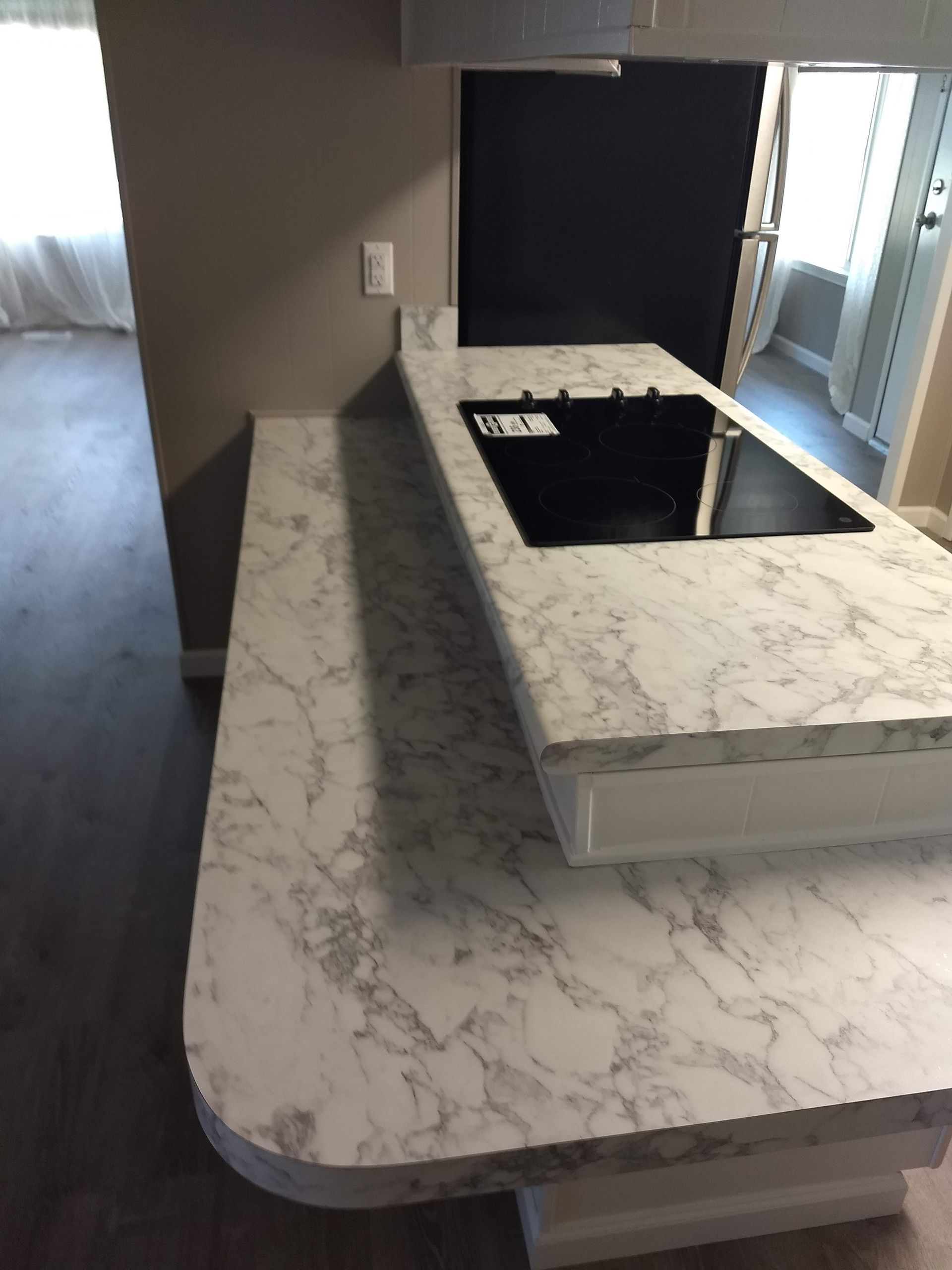 A kitchen with a marble counter top and a stove top oven