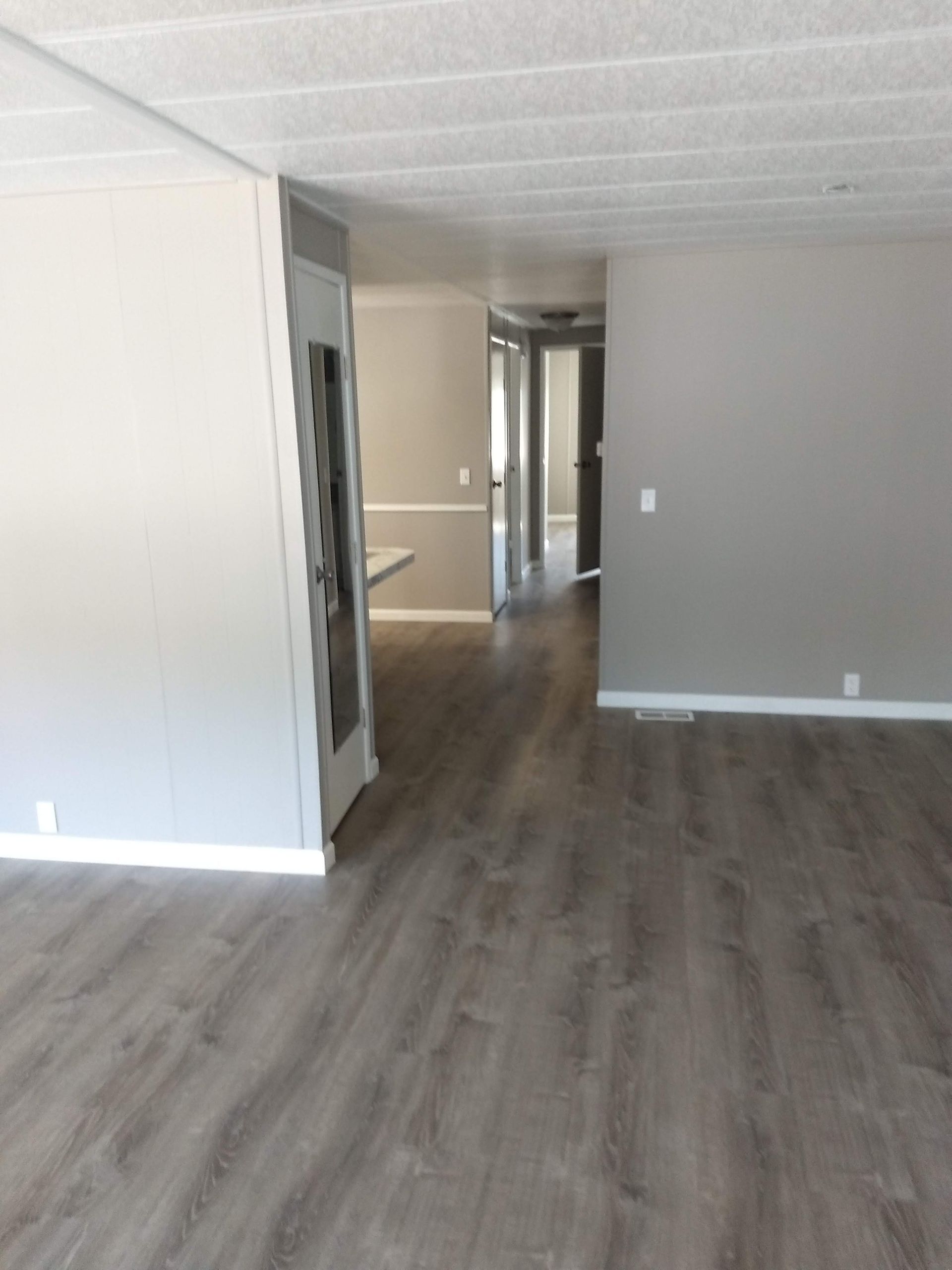 An empty room with hardwood floors and gray walls