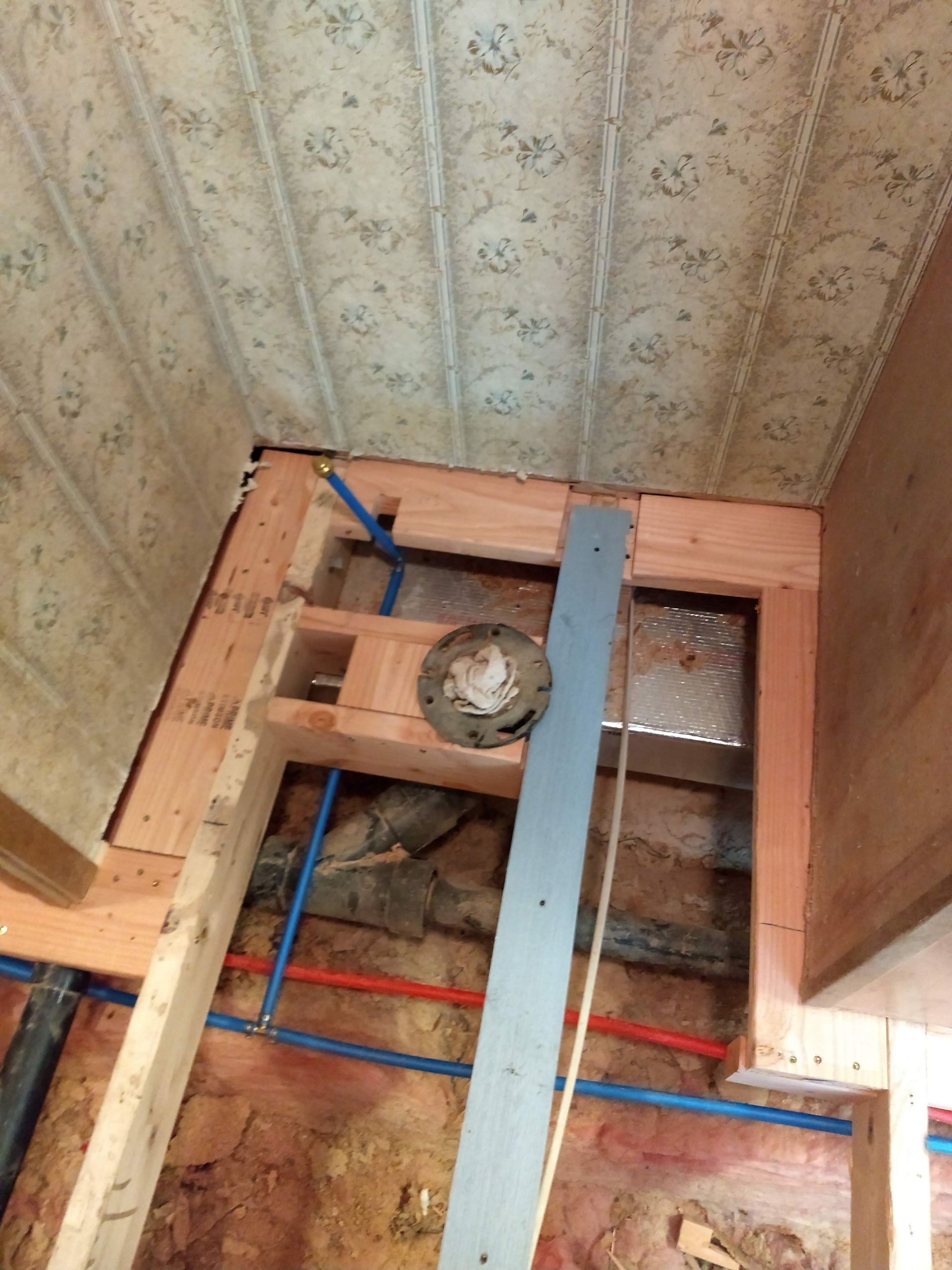 A bathroom under construction with a drain in the floor