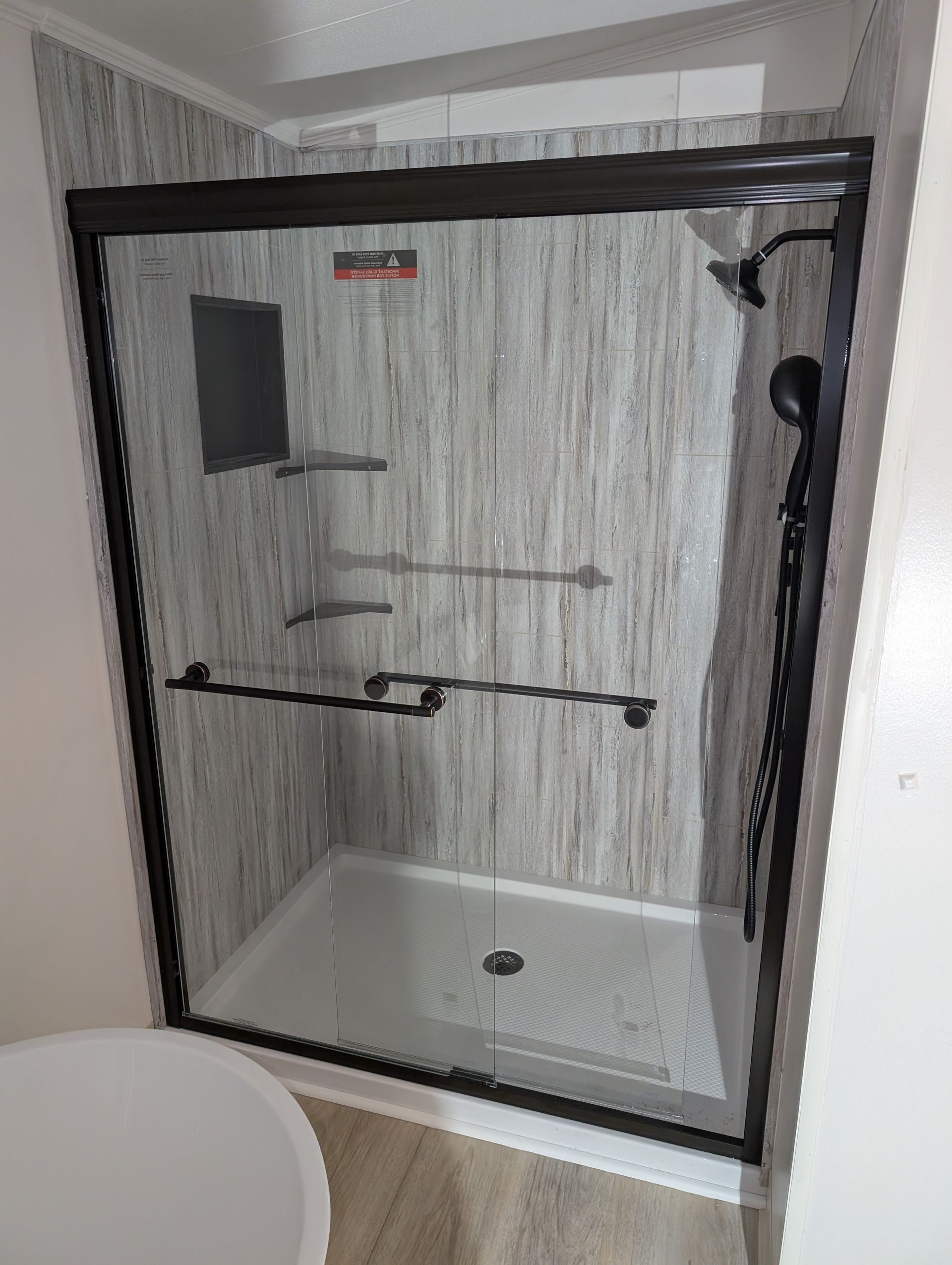 A bathroom with a sliding glass shower door and a toilet.