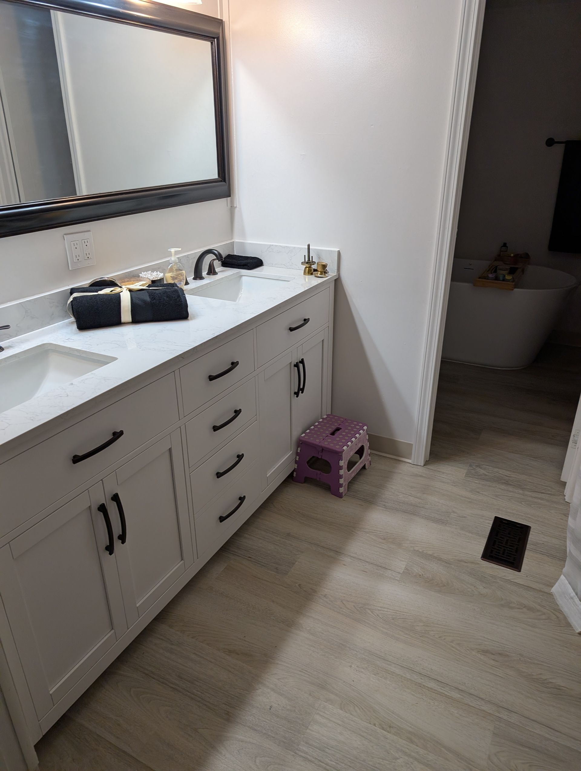 A bathroom with two sinks , a mirror and a bathtub.