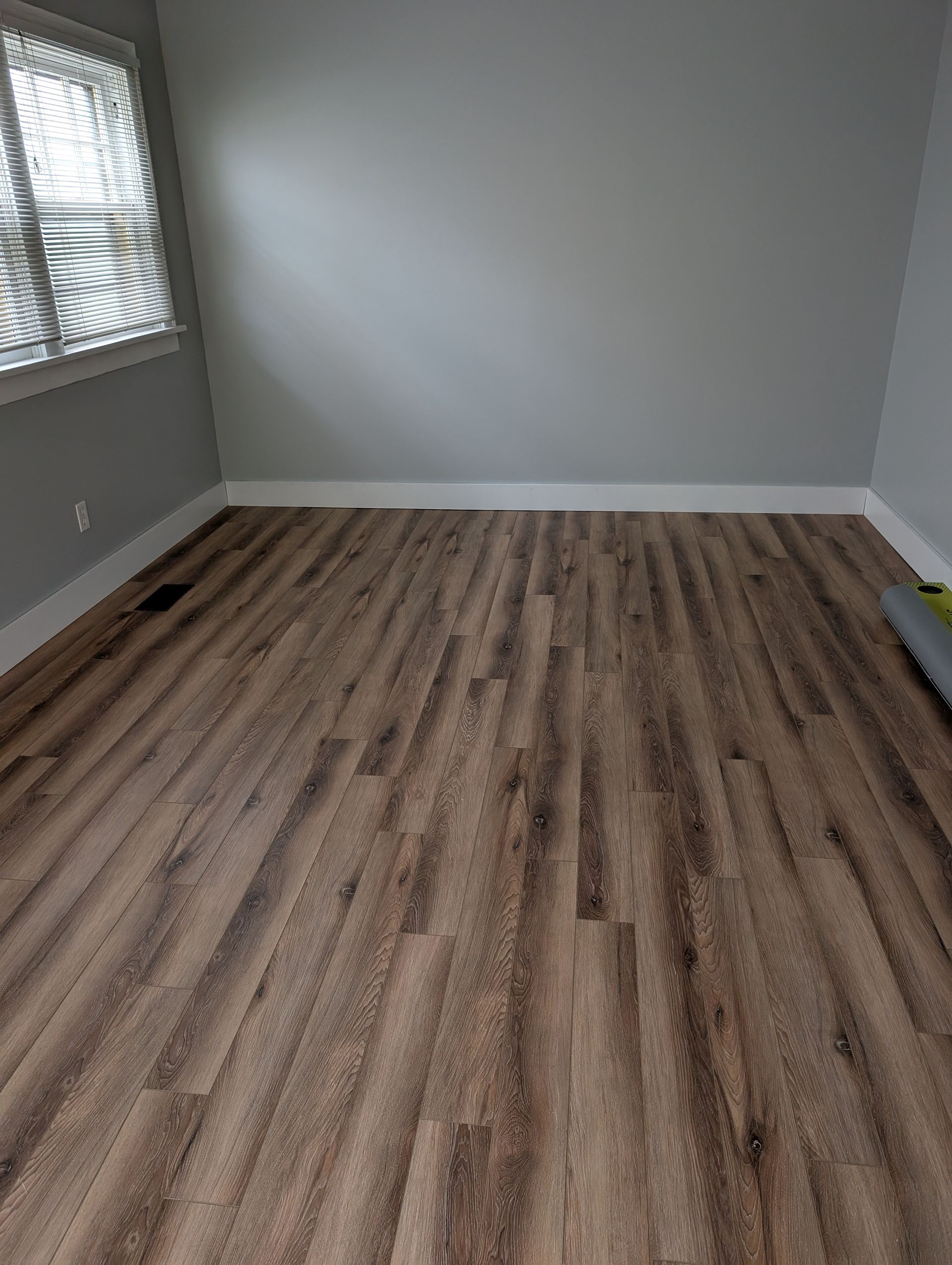 A room with hardwood floors and a window.