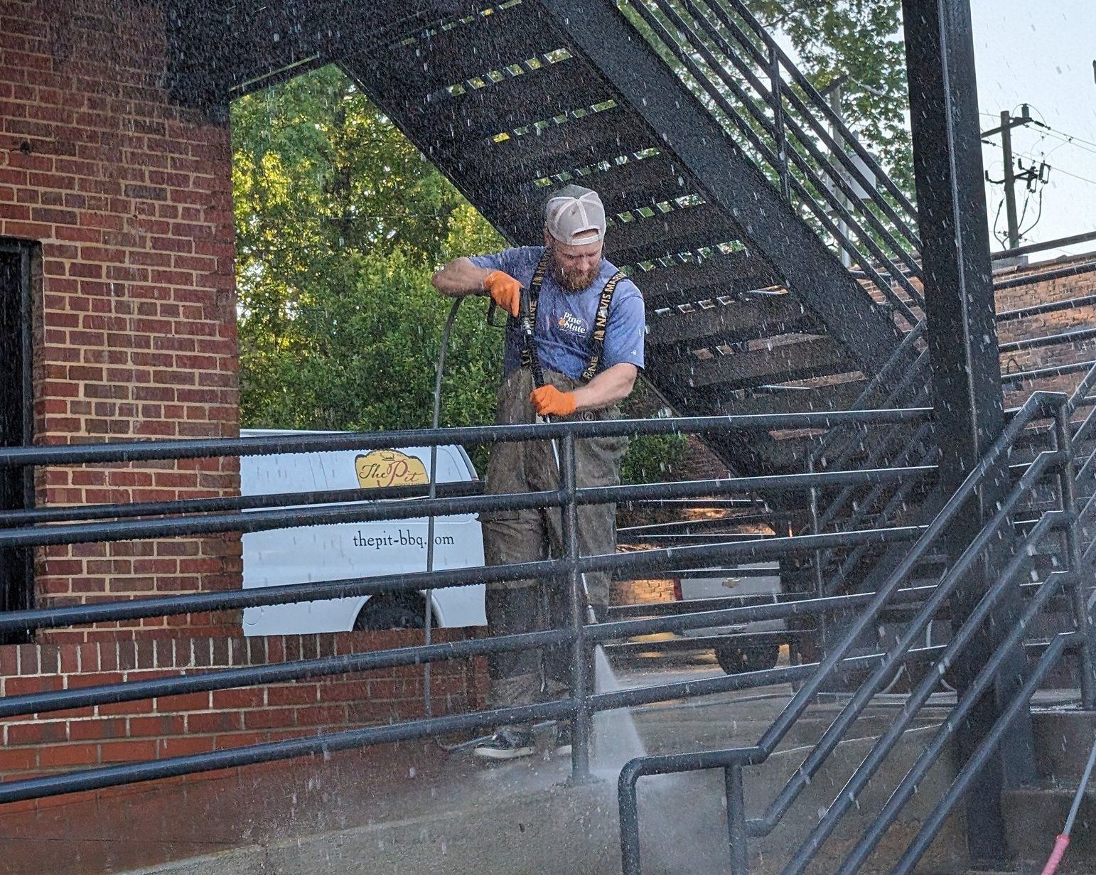 A man is cleaning a staircase with a high pressure washer.