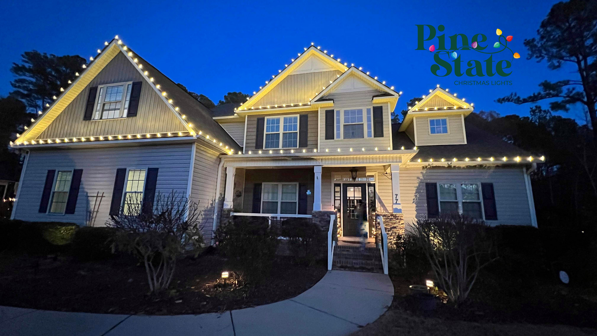 A house with christmas lights on it is lit up at night