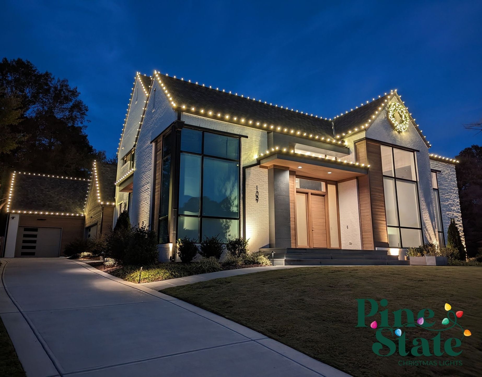 A house with christmas lights on it is lit up at night