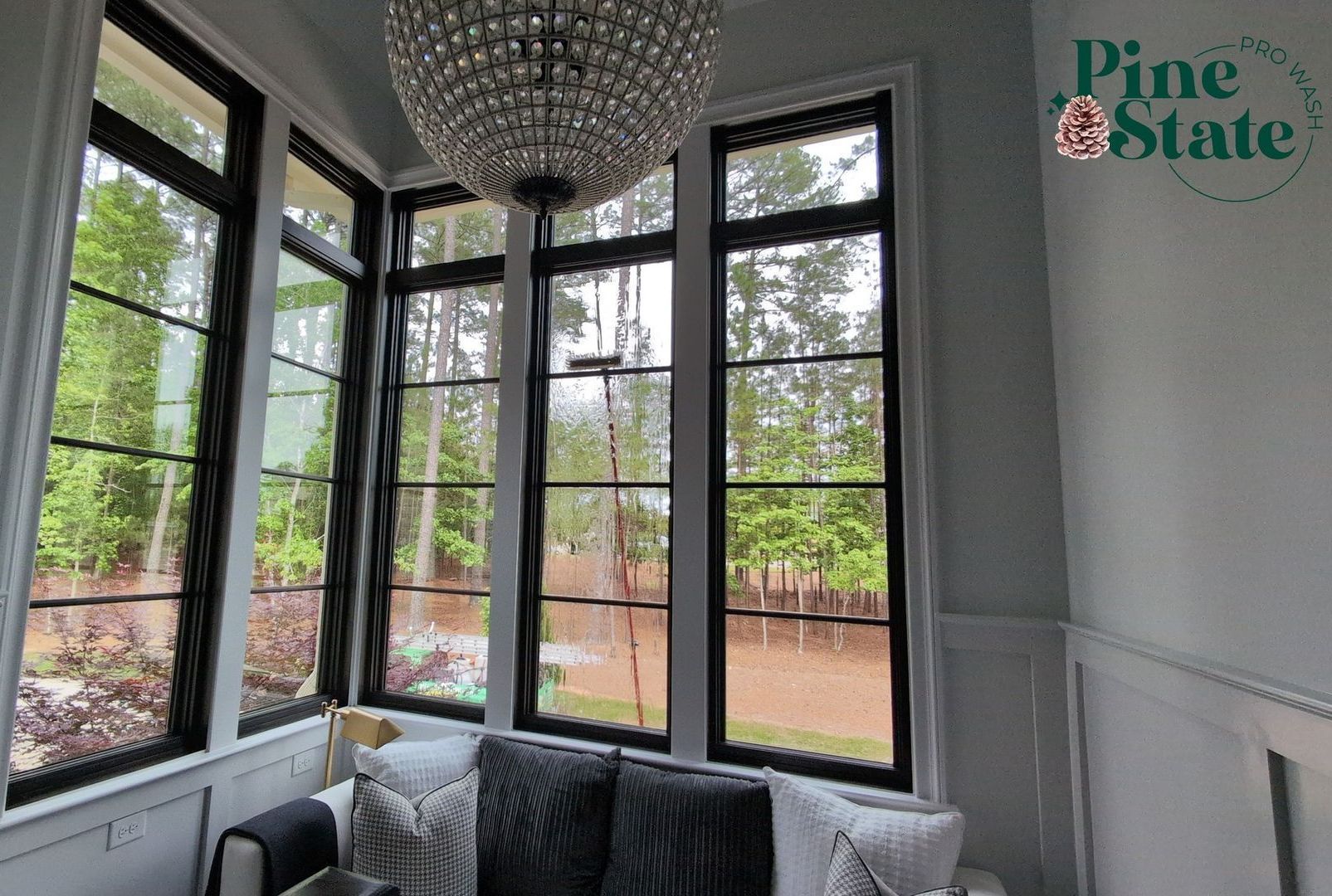 A living room with a lot of windows and a chandelier hanging from the ceiling.