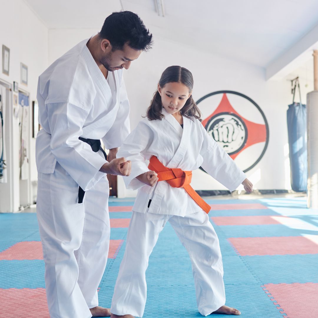 A group of men are practicing karate in a gym.