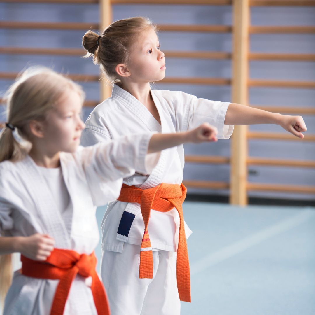 A boy and a girl are practicing taekwondo together.