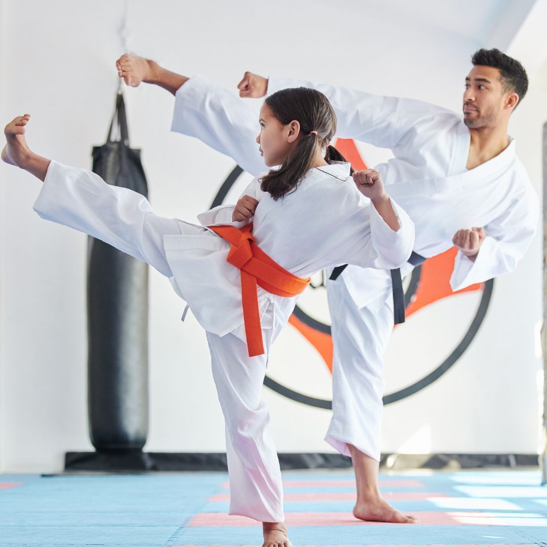 Two young men are practicing karate on a mat