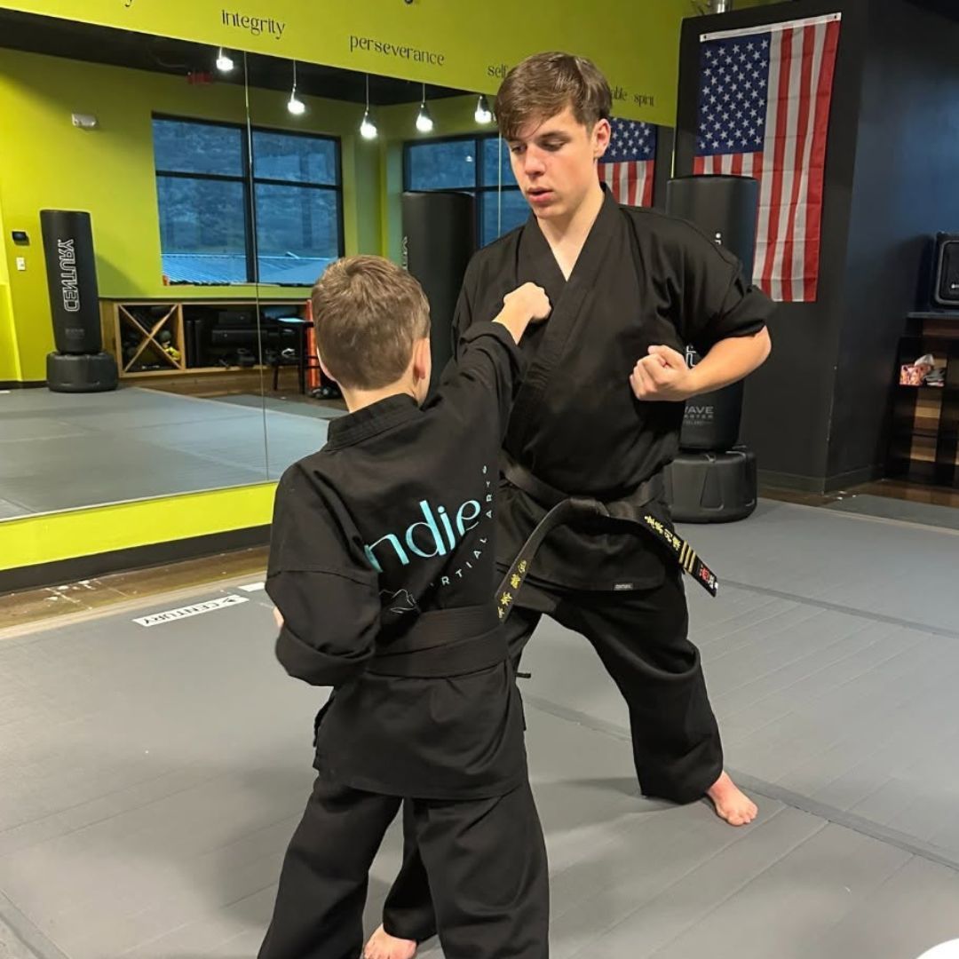 A boy and a girl are practicing taekwondo together.