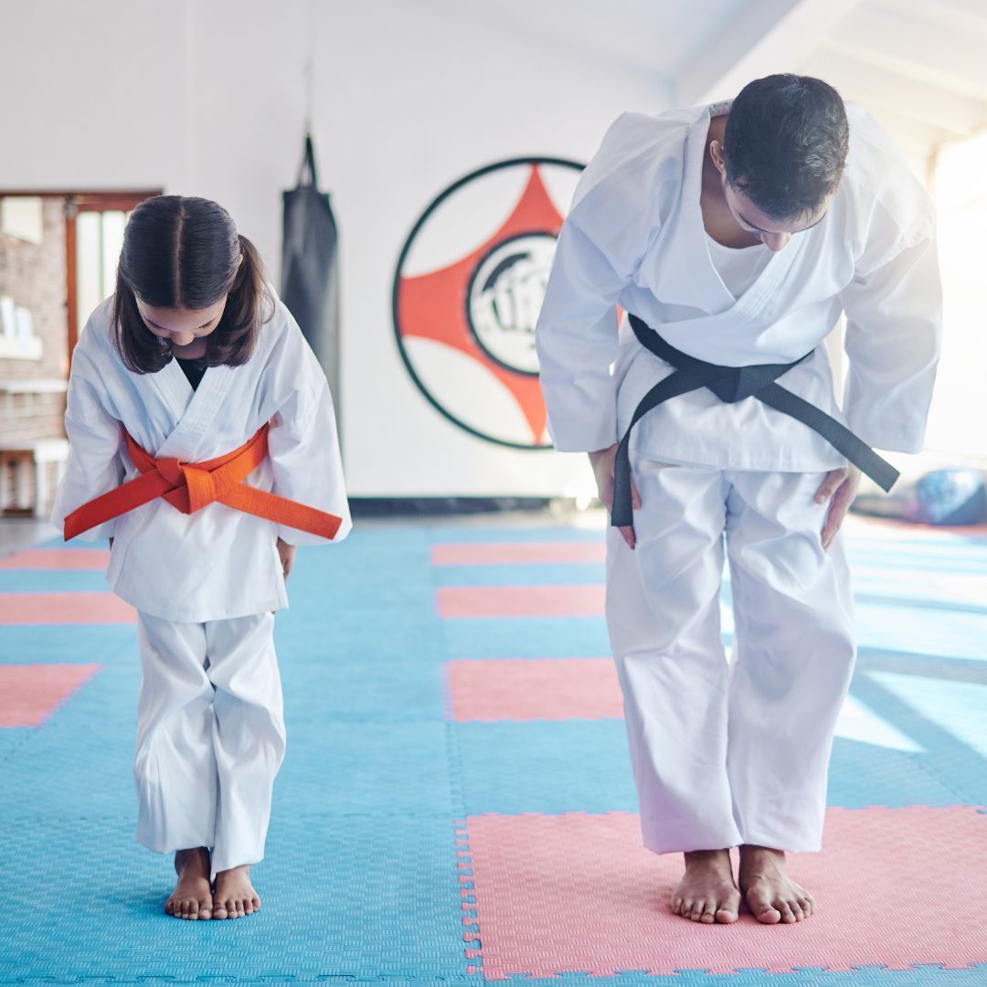 A group of men are practicing karate in a gym.