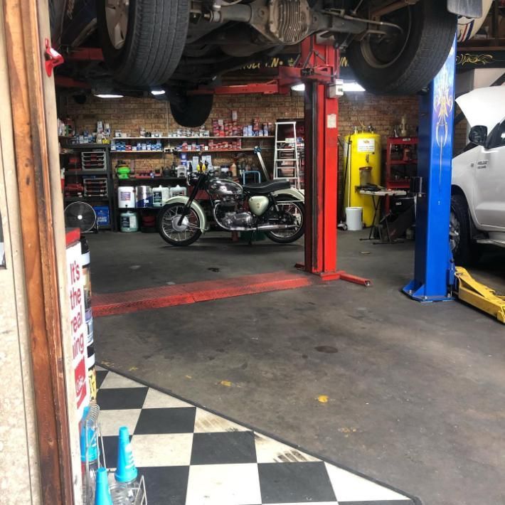 A Motorcycle is on a Lift in a Garage — Coastal Automotive Services Long Jetty in The Entrance, NSW