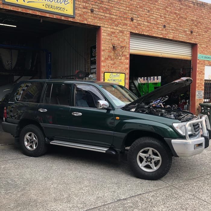A Green Suv With the Hood Up is Parked in Front of a Garage — Coastal Automotive Services Long Jetty in Long Jetty, NSW