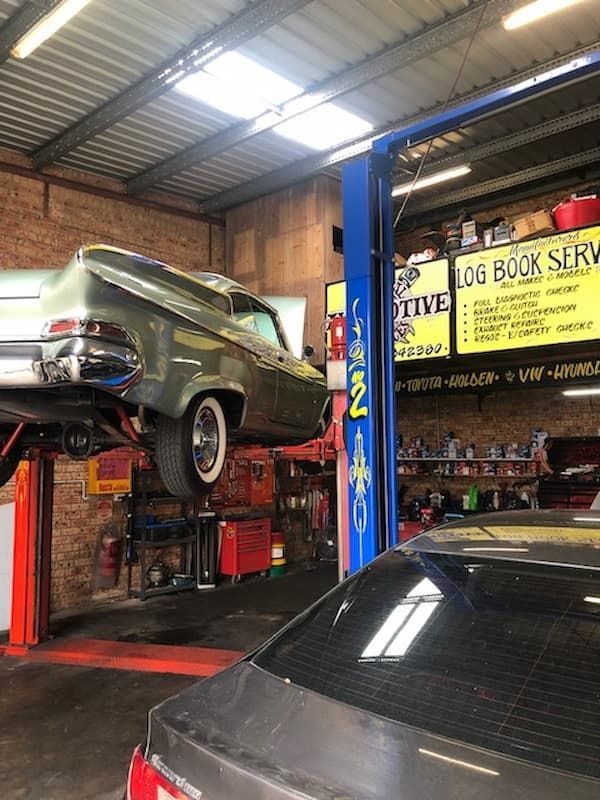 A Car is Sitting on Top of a Lift in a Garage — Coastal Automotive Services Long Jetty in Long Jetty, NSW