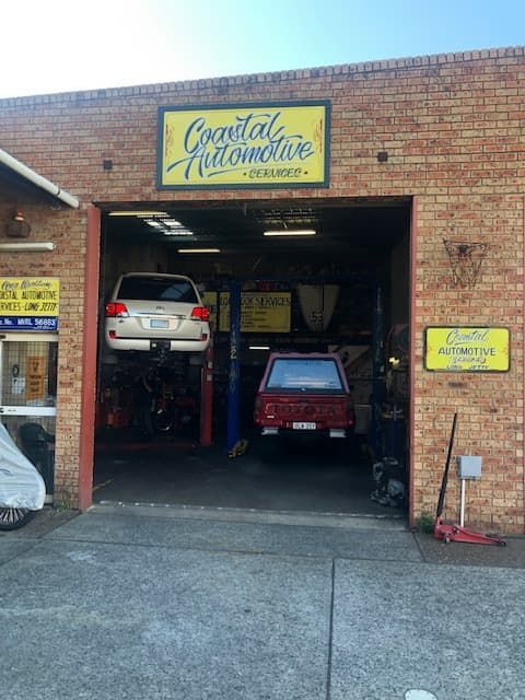 A Car is Sitting on a Lift in a Garage — Coastal Automotive Services Long Jetty in Long Jetty, NSW