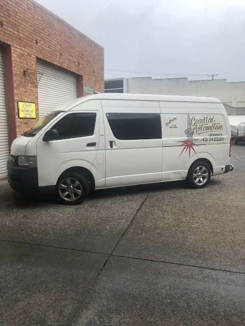 A White Van is Parked in Front of a Brick Building — Coastal Automotive Services Long Jetty in Long Jetty, NSW
